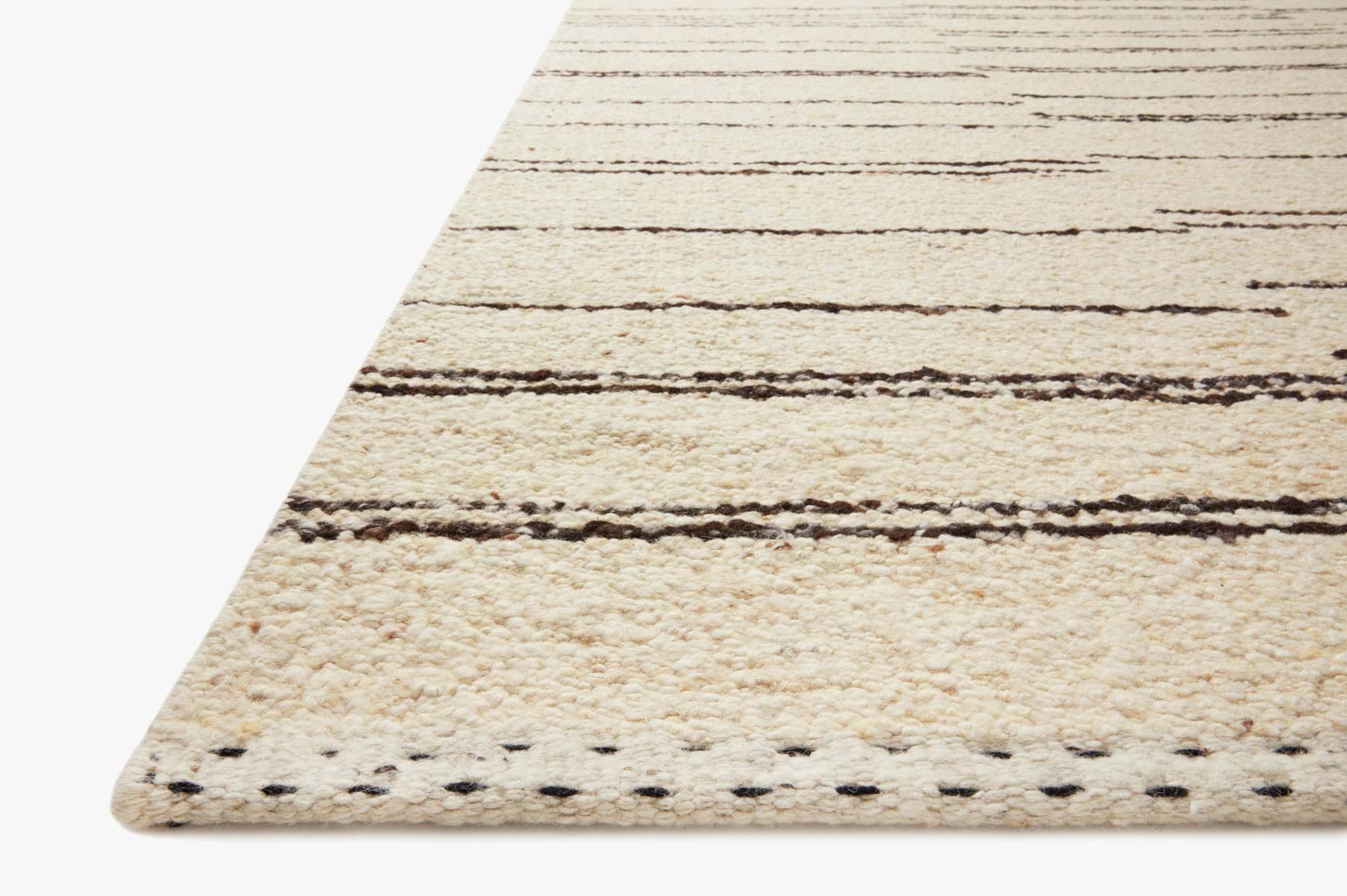 Hand-woven rug corner detail with cream base and charcoal stripe rows