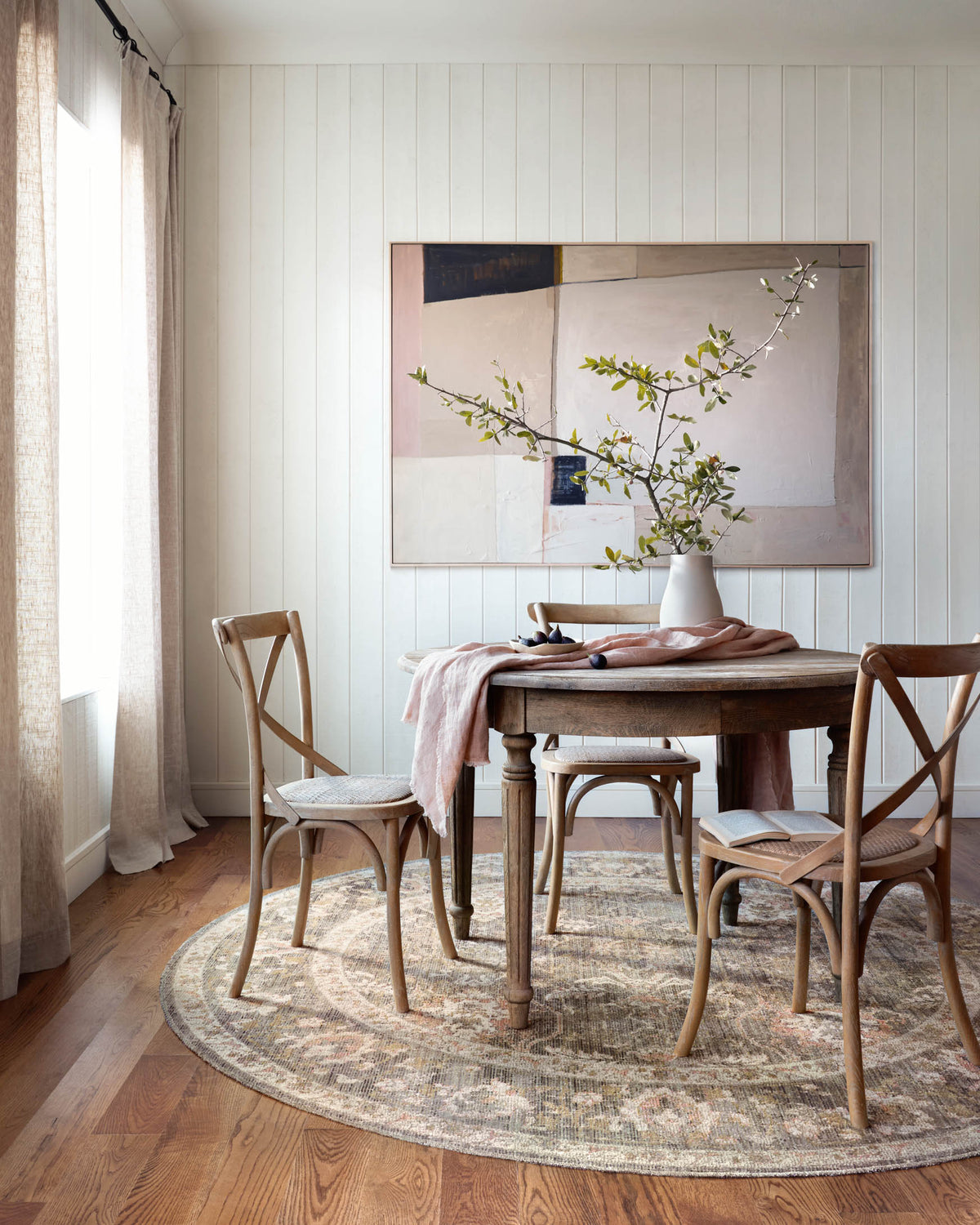 Traditional round-edged area rug with distressed pattern in sage, blush, and ivory.