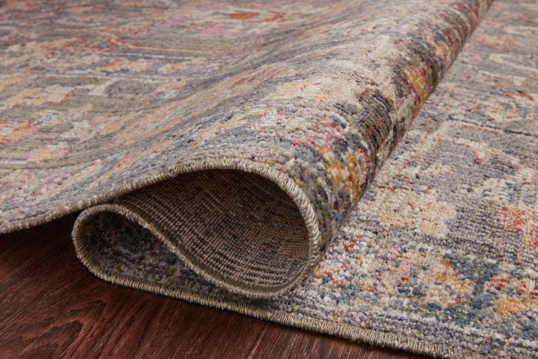 Rug edge detail with low-pile texture and multicolor woven pattern in stone
