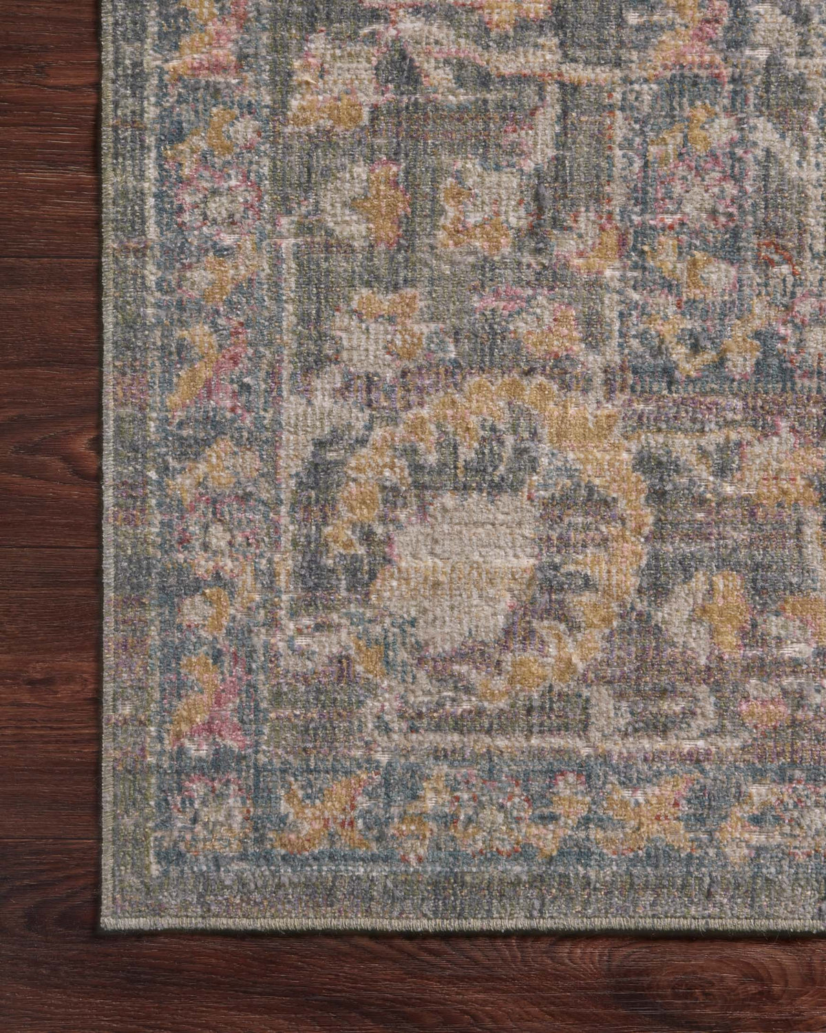 Corner view of stone-toned traditional area rug with multicolor pattern and border