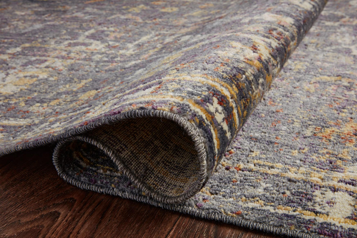Rug edge detail with dark binding and low-pile texture on a warm wood floor.