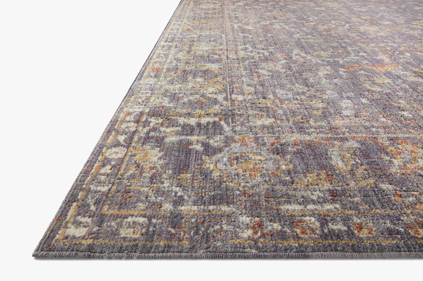 Corner view of graphite distressed abstract rug with textured woven look.