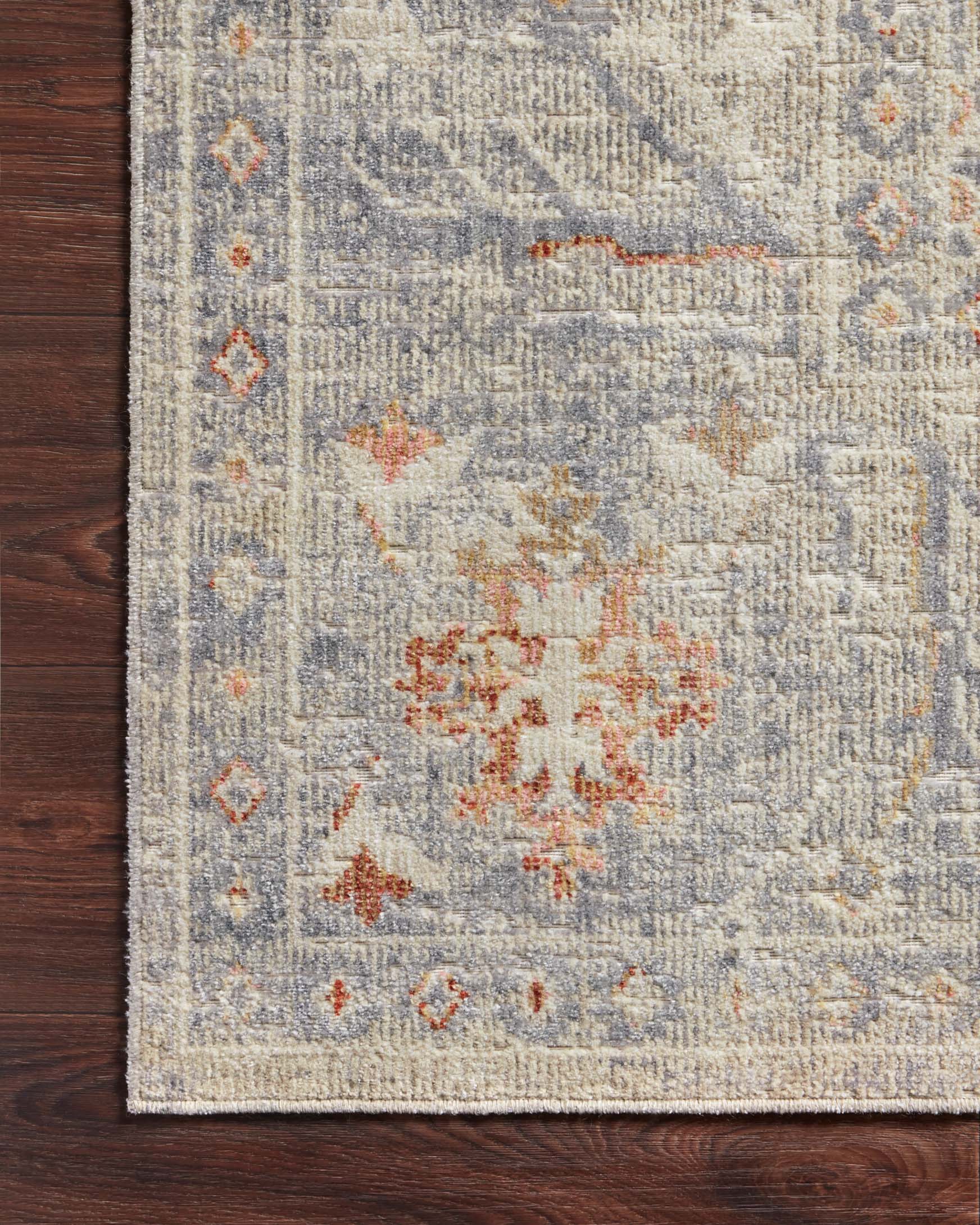 Traditional power-loomed rug corner detail in oatmeal with lavender and orange floral medallions