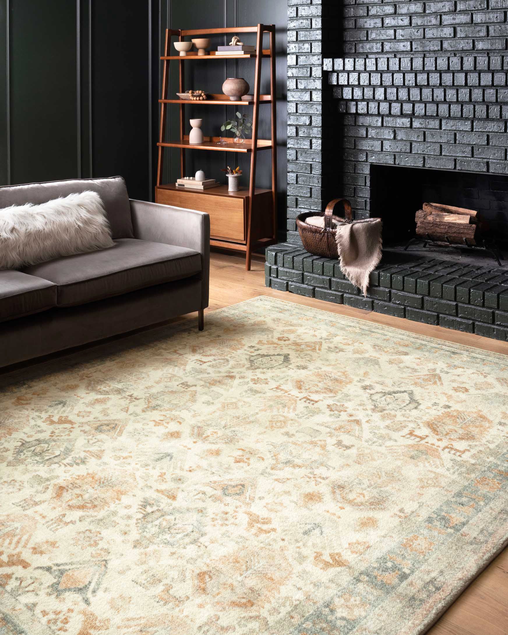 Beige area rug with ornate distressed pattern and light teal and rust accents