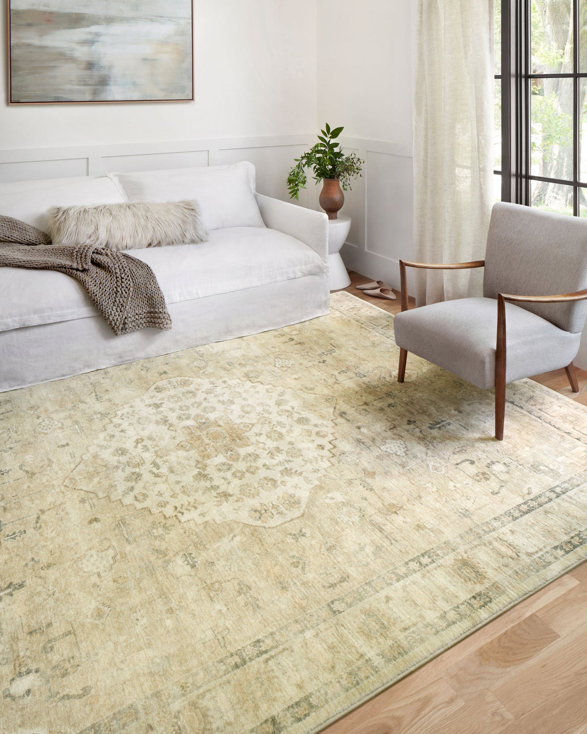 Sand and ivory traditional rug displayed under living room seating with subtle distressed pattern