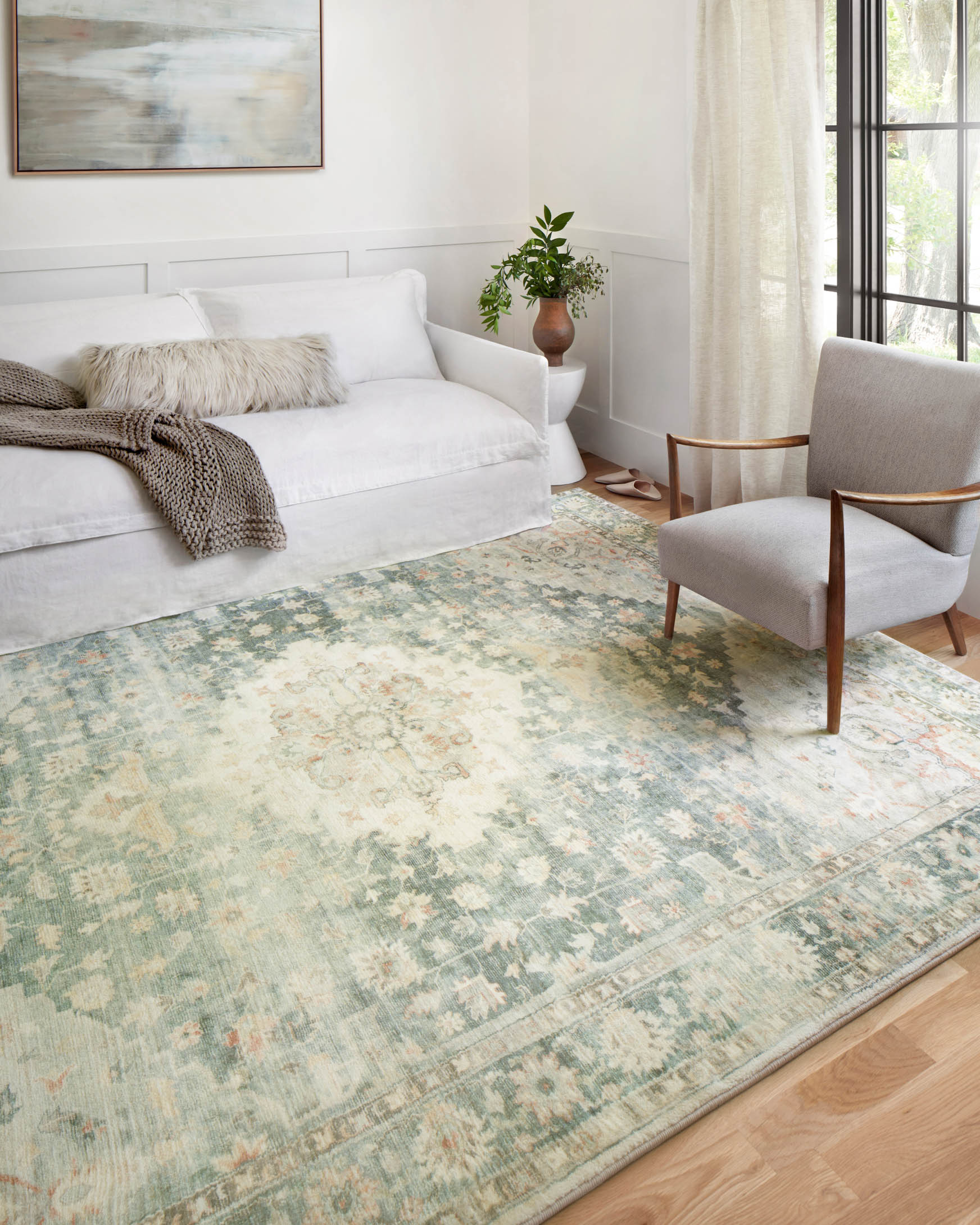 Rectangular teal and ivory vintage-style rug with distressed floral medallion look.