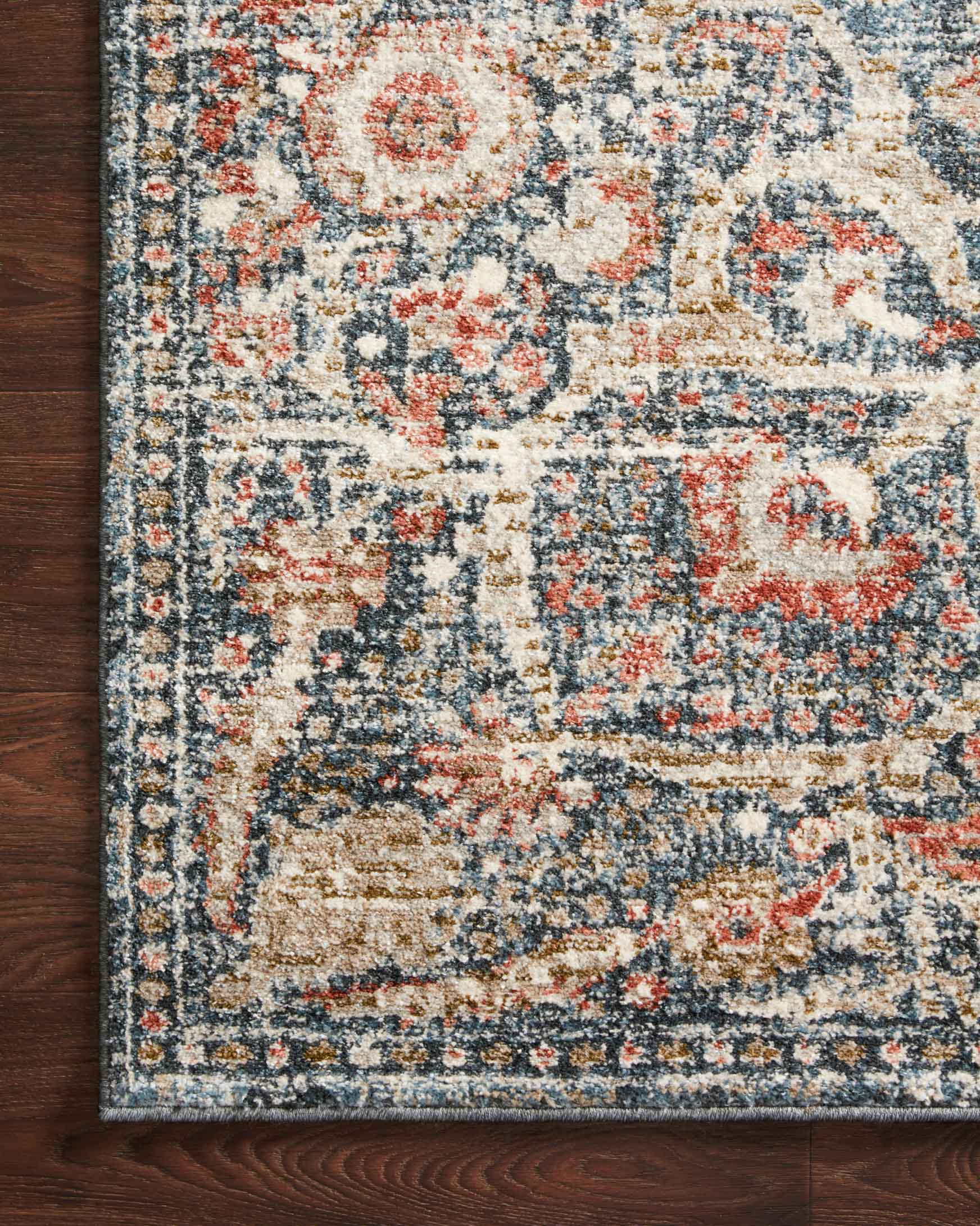 Traditional power-loomed rug corner close-up with blue ground and floral medallion motifs