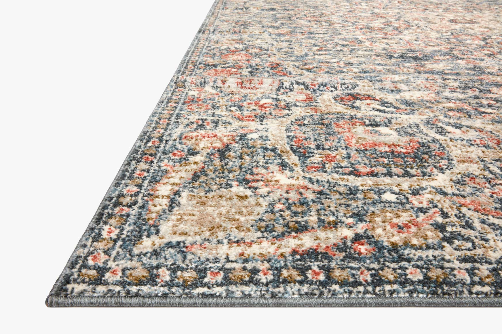 Traditional power-loomed rug close corner view in blue with cream and orange details