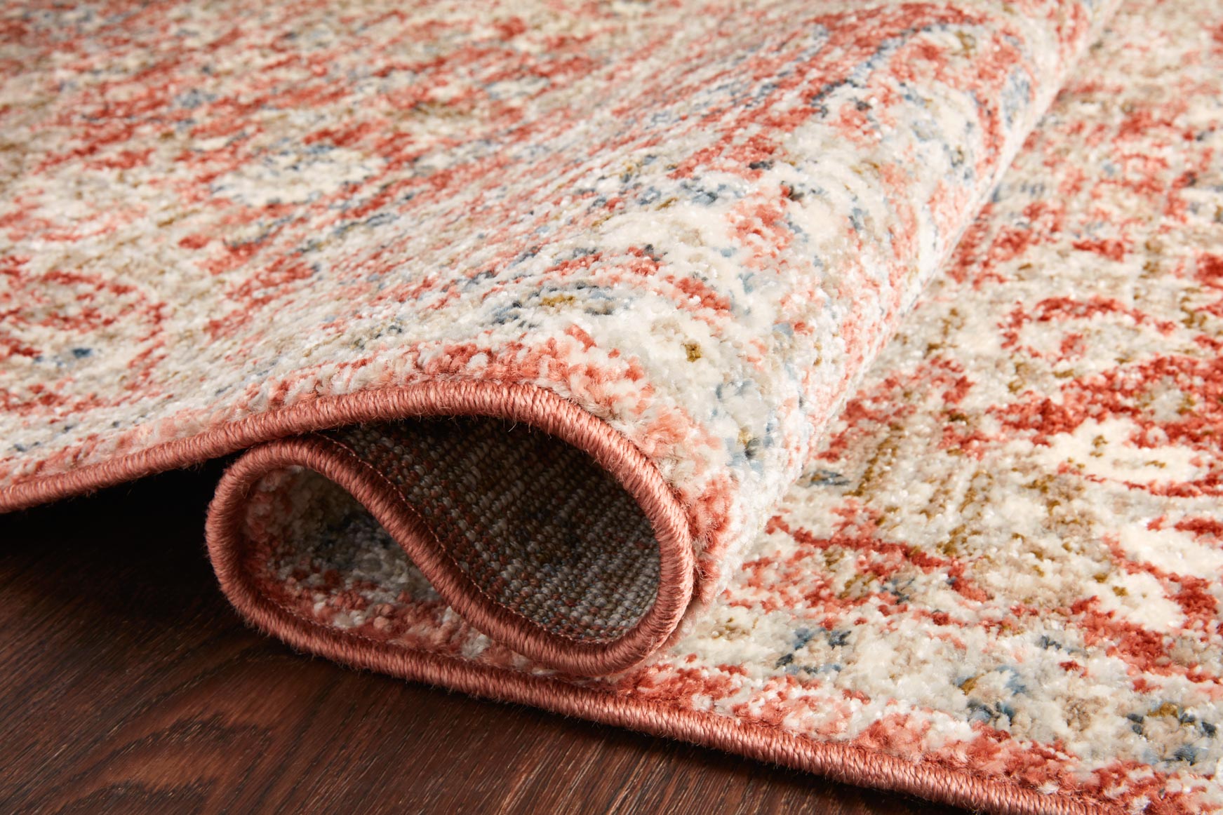 Rust and beige rug with rolled edge detail and textured surface