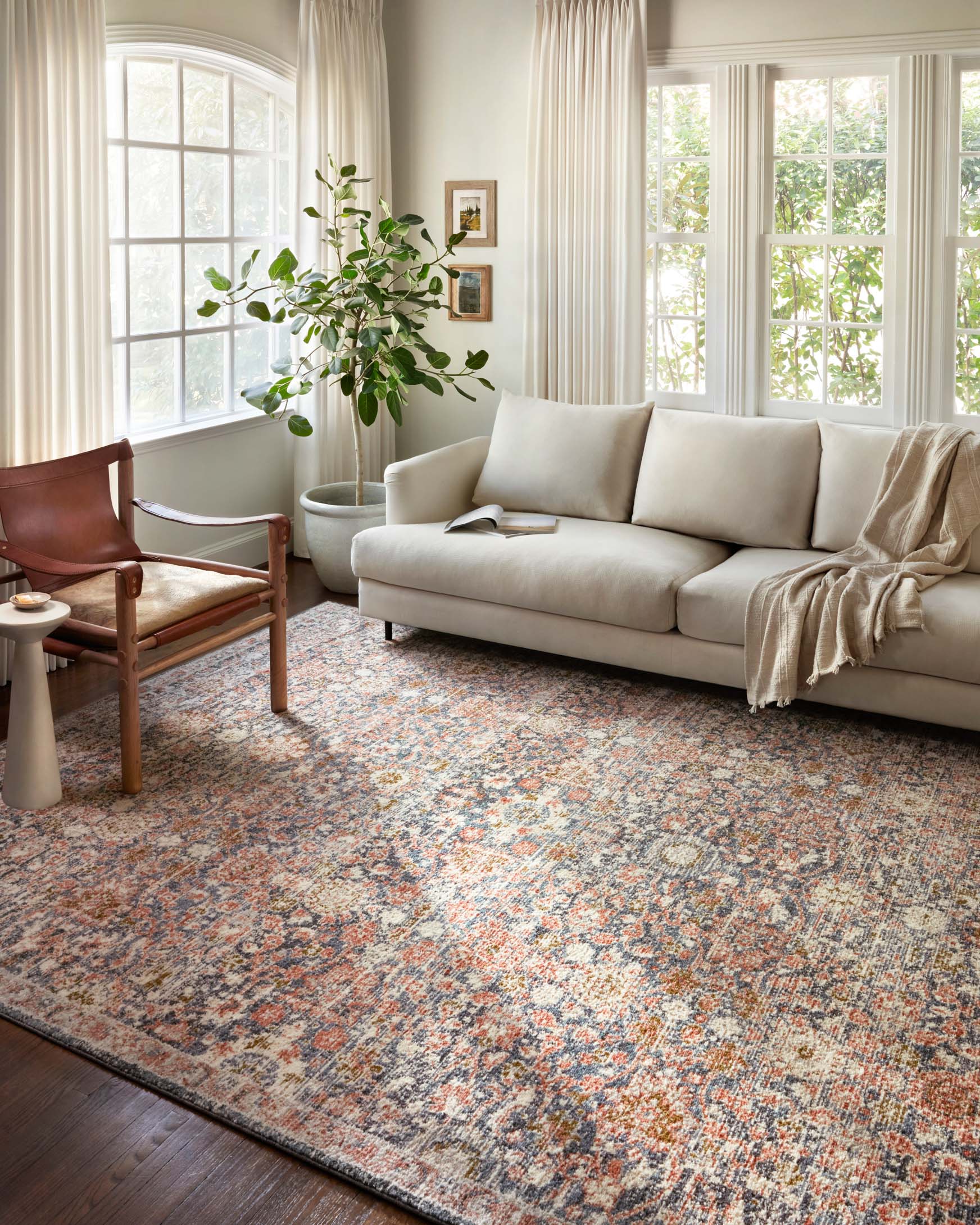 Traditional area rug with distressed medallion design, light tones with blue and rust speckling