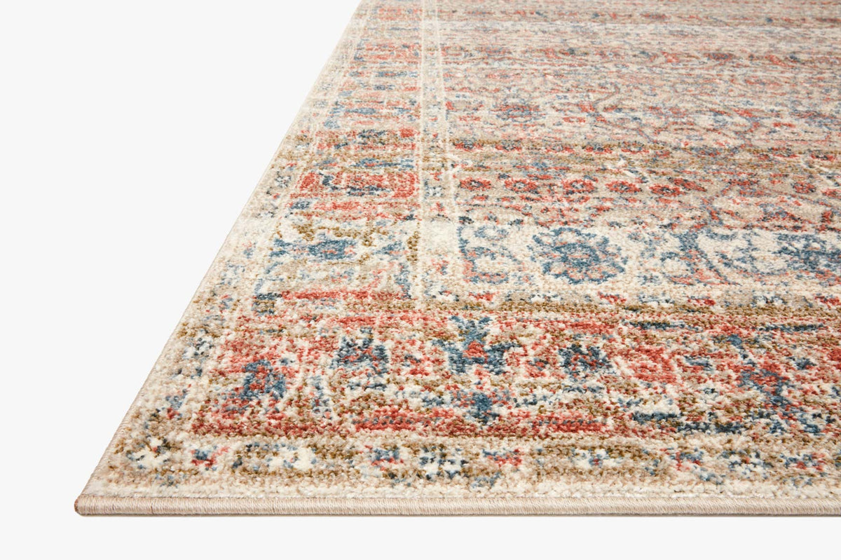 Corner view of sand-and-rust traditional area rug with blue pattern accents