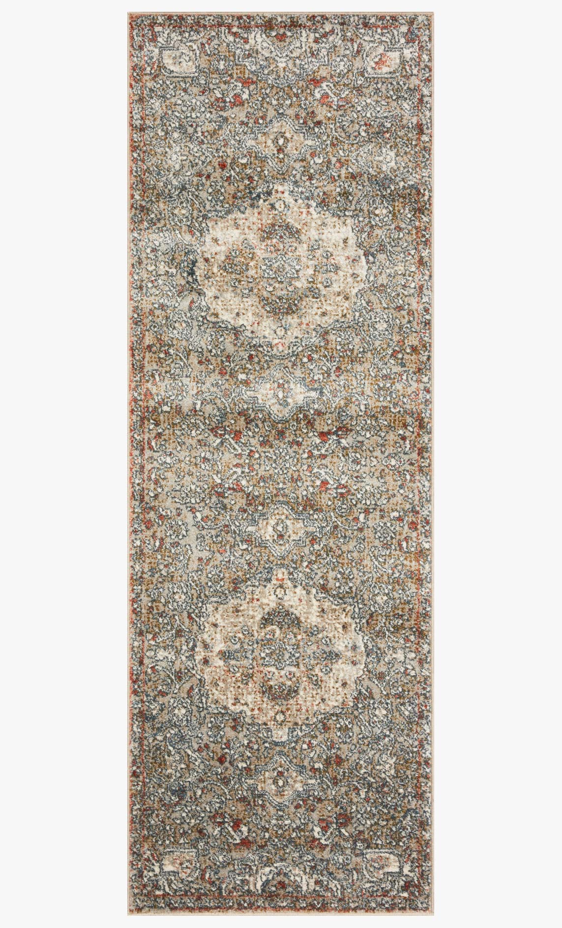 Beige and blue-gray area rug with repeating ornate patterns and speckled distressed look.