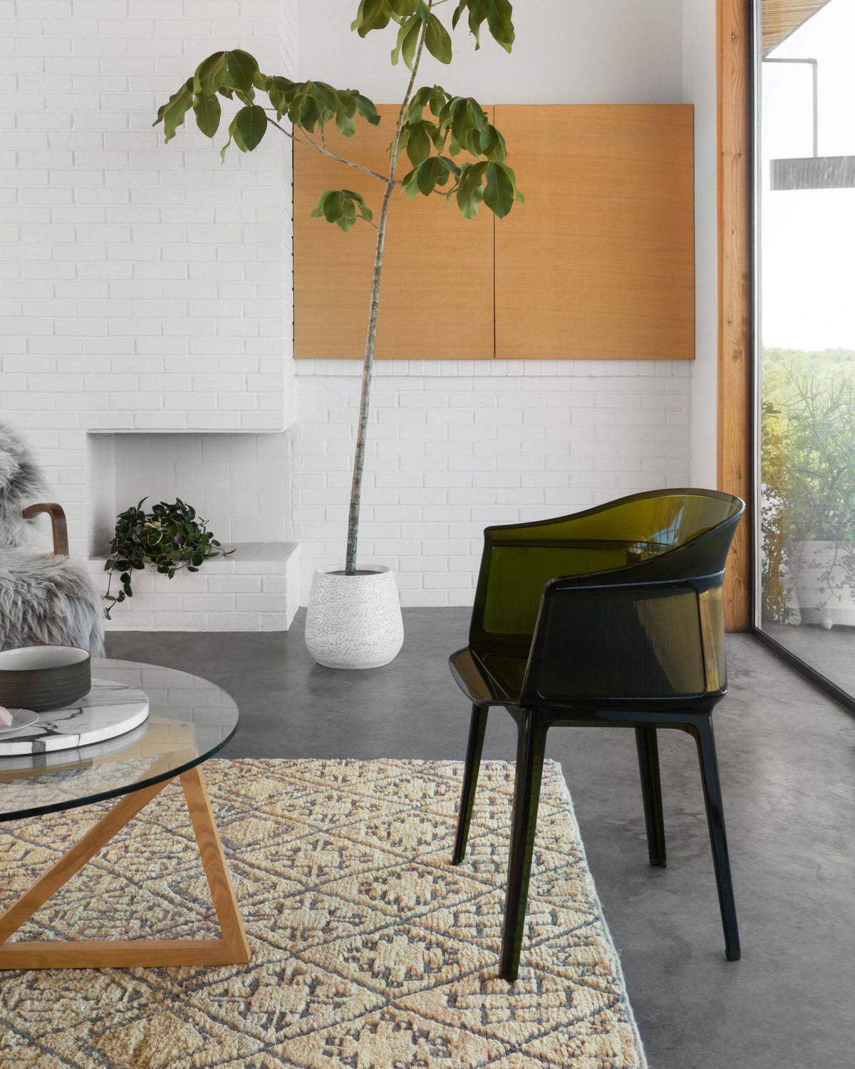 Tan and dark blue geometric hand-knotted rug laid on the floor under furniture.
