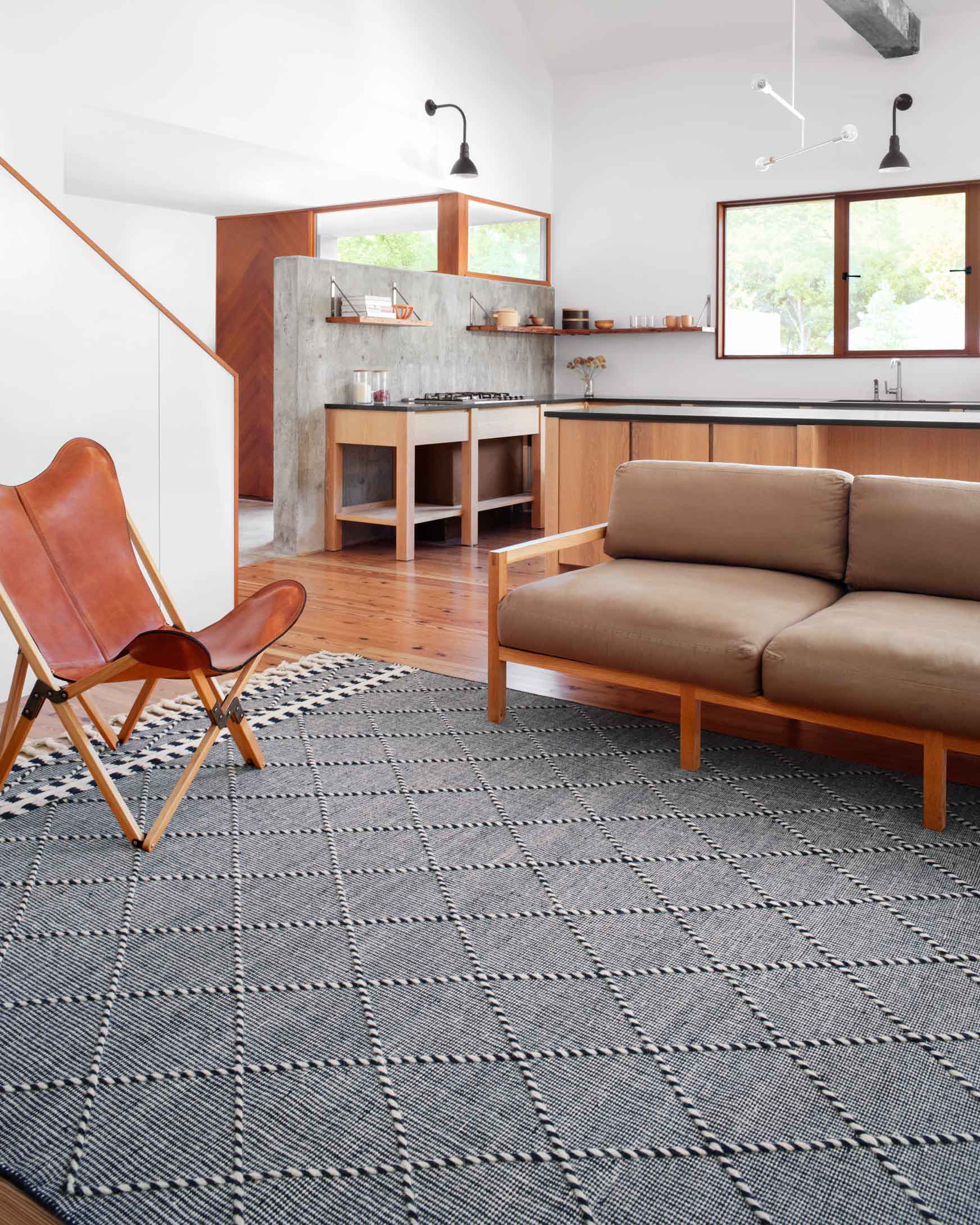 Rug with navy and off-white geometric diamond pattern and short fringe