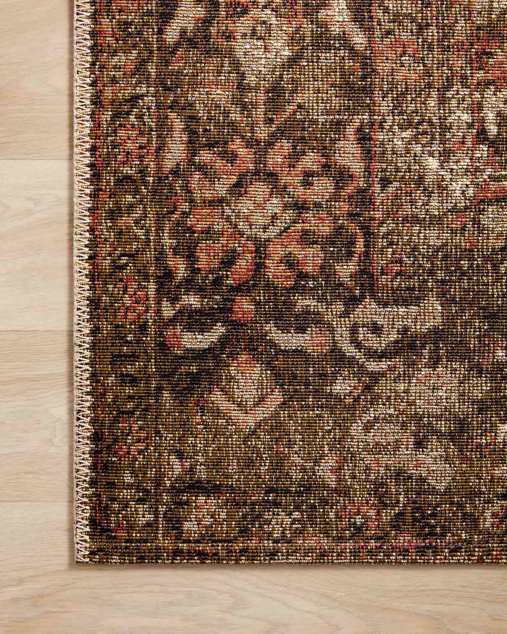 Traditional power-loomed rug texture close-up in rust and tobacco with floral medallion