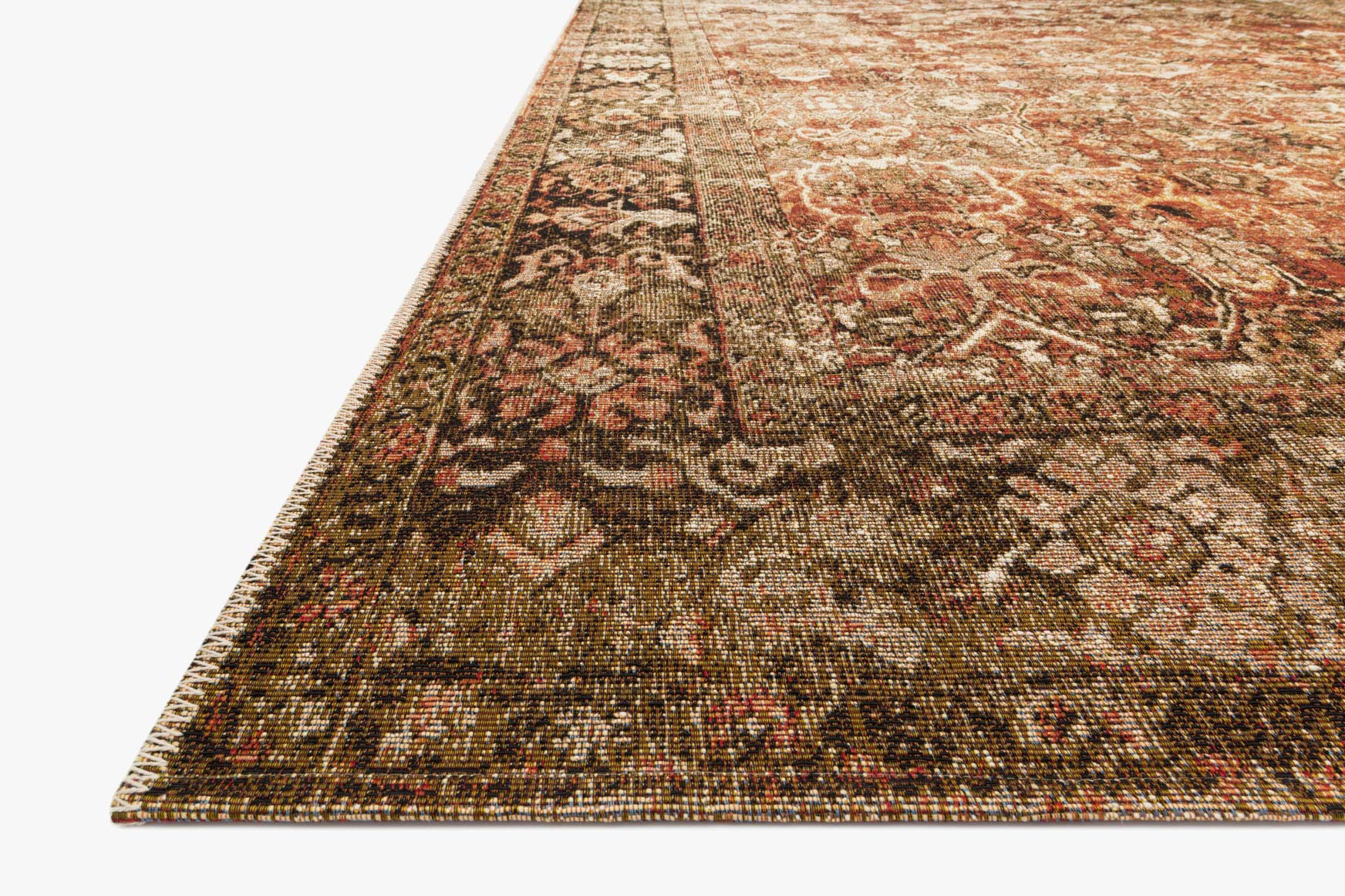 Traditional power-loomed rug corner detail with rust, tobacco, and cream patterned border