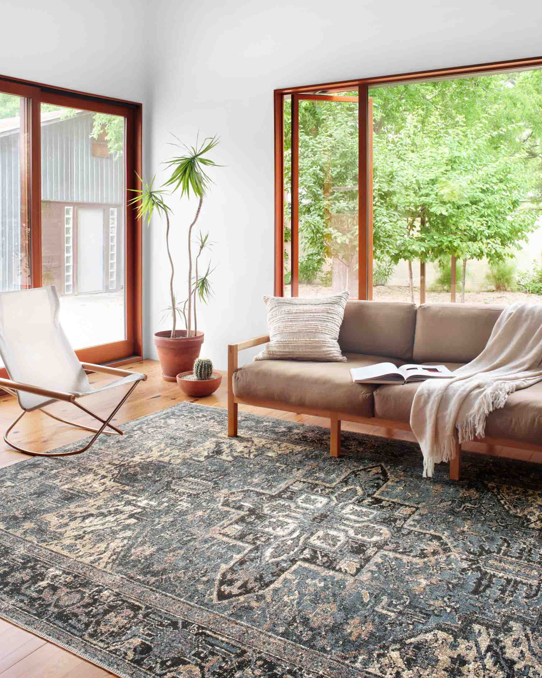 Traditional blue and dark navy area rug with ornate geometry pattern on a living room floor