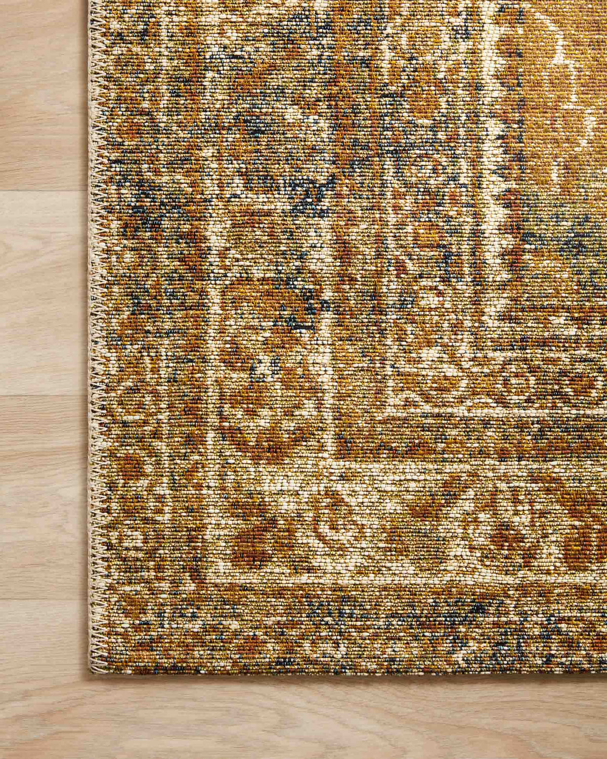 Close-up of lagoon blue-green and spice power-loomed rug edge and texture