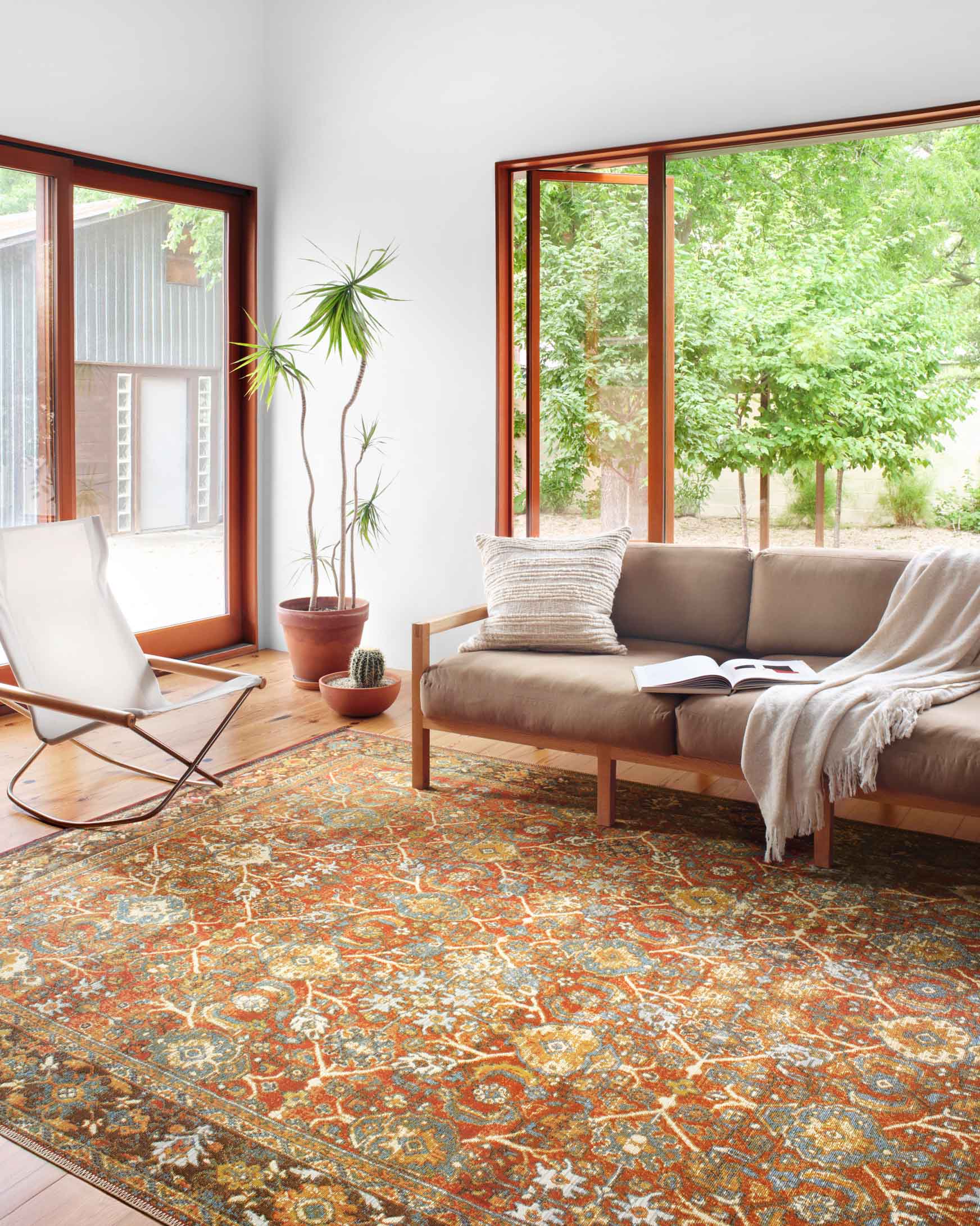 Red, orange, and blue ornate rug with central medallion and striped border