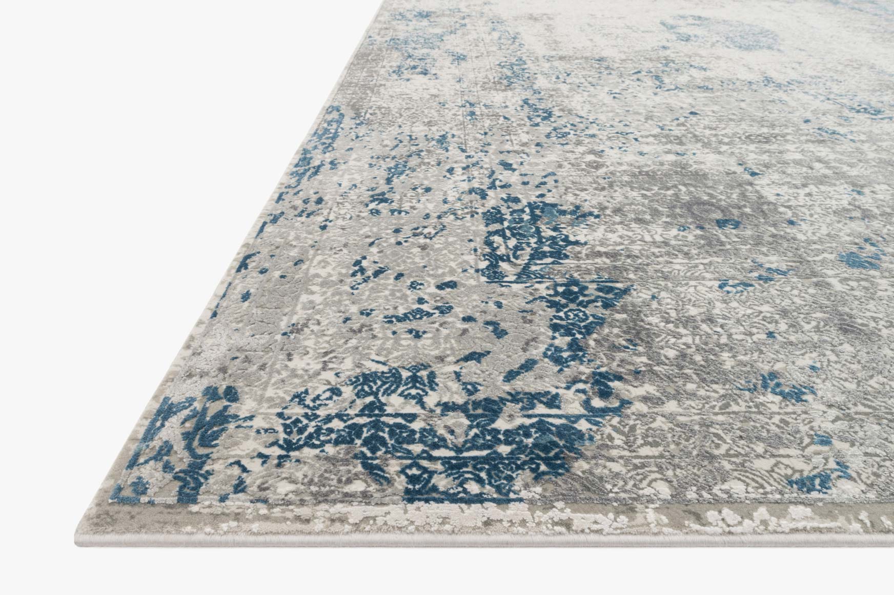 Rectangular rug corner view with distressed blue motifs on light gray dove background.