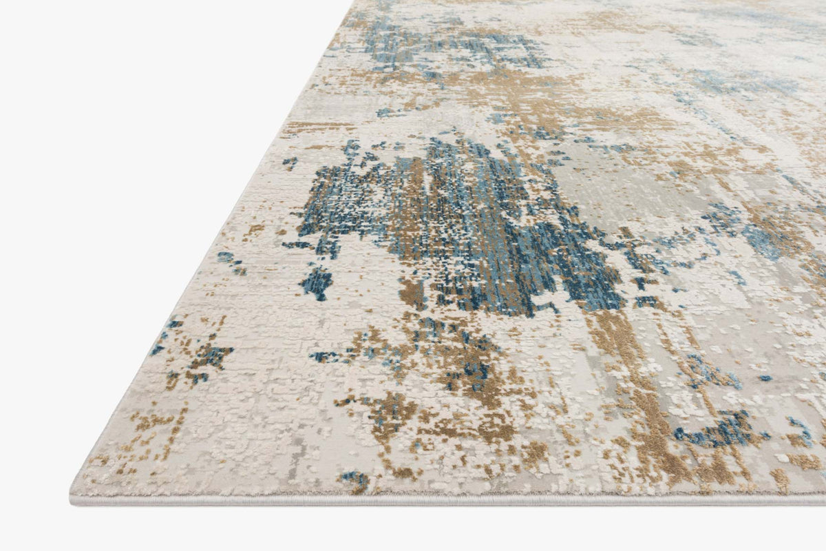 Ivory abstract rug with distressed blue and gold design, angled view