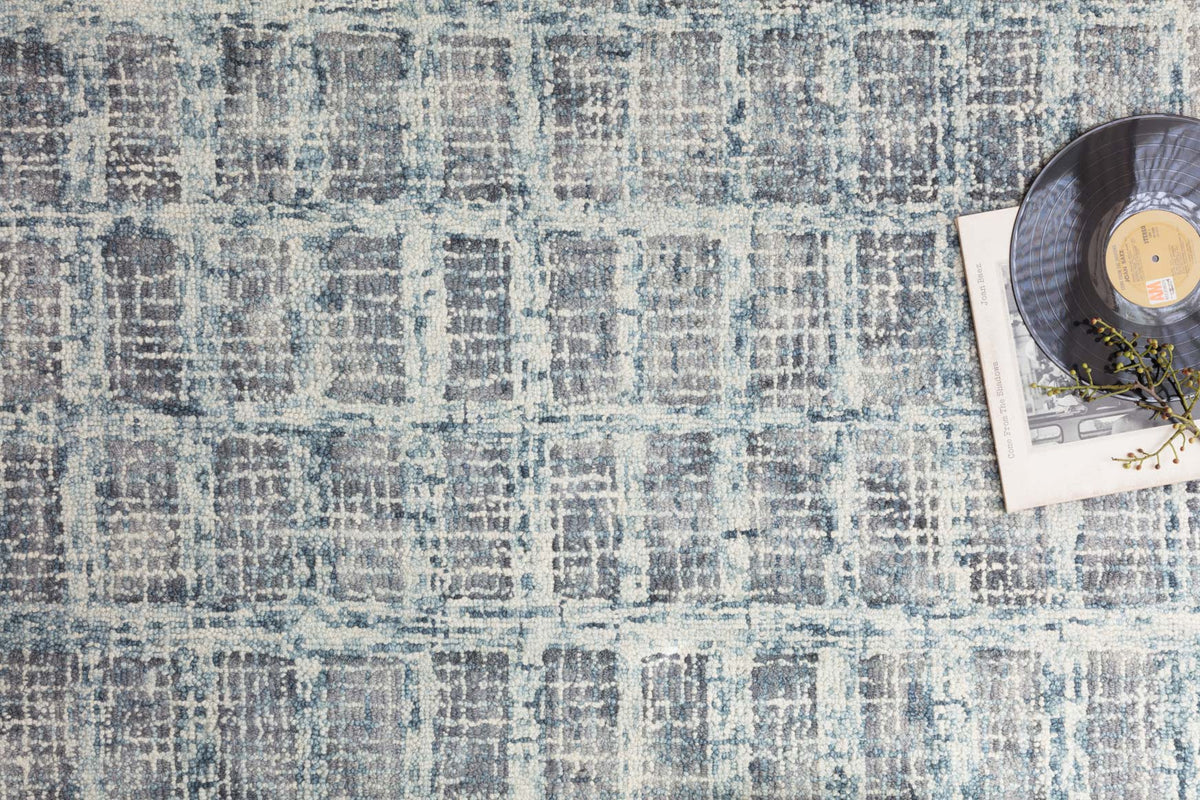 Blue hooked rug with distressed abstract motif and textured grid surface