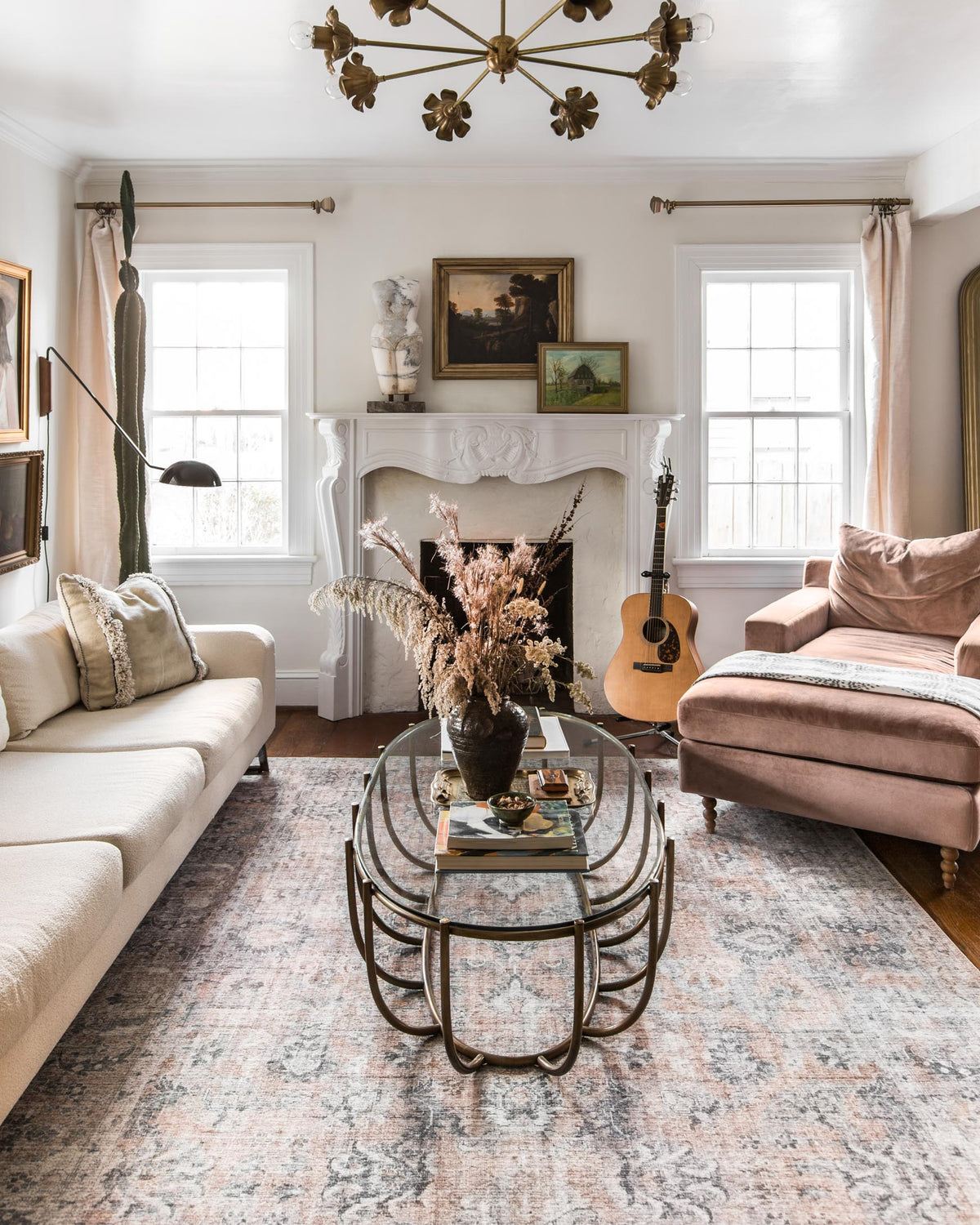 Blush and grey area rug with distressed pattern beneath coffee table in living room.