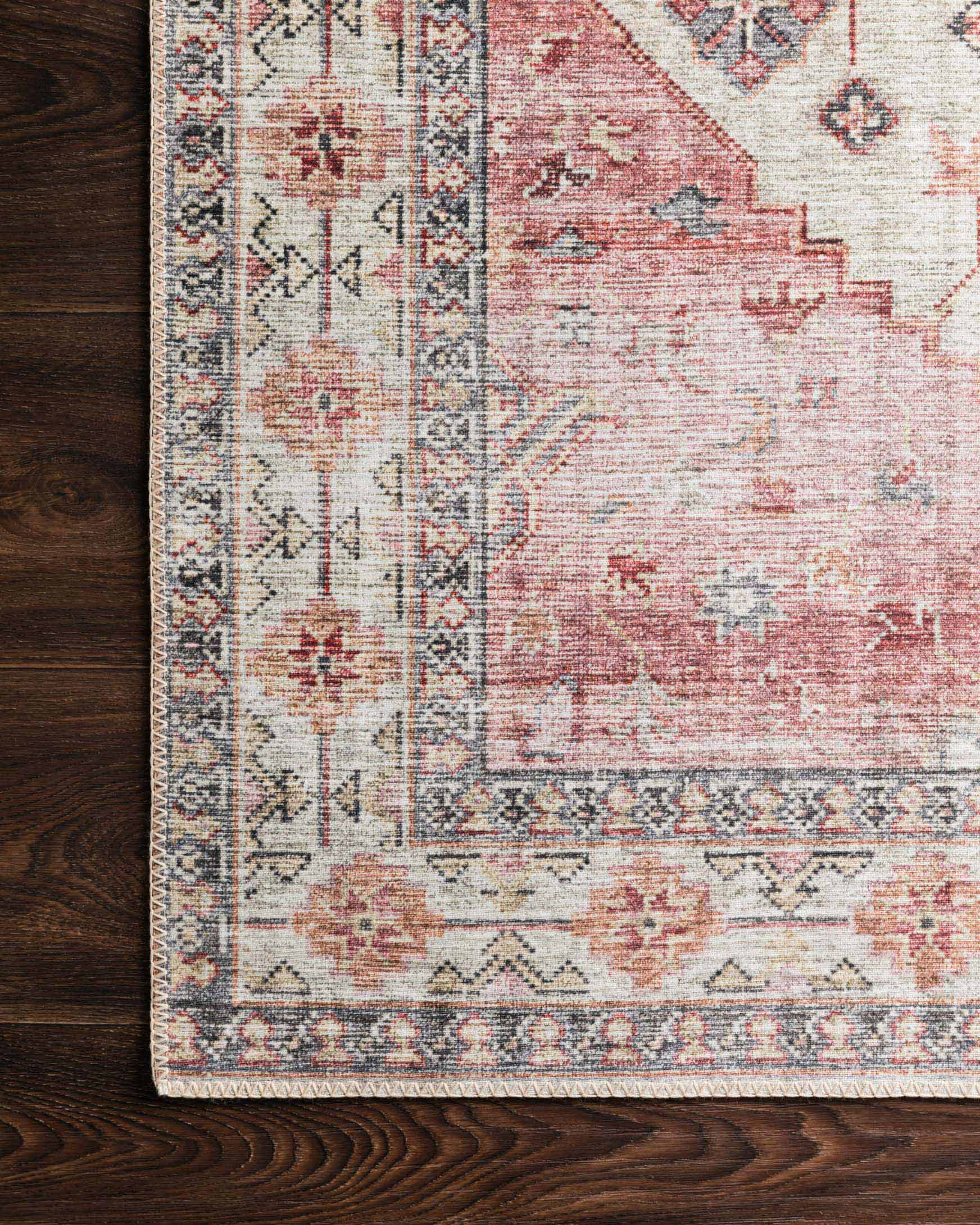 Traditional rug corner with ivory base, berry-red distress, and dark geometric trim