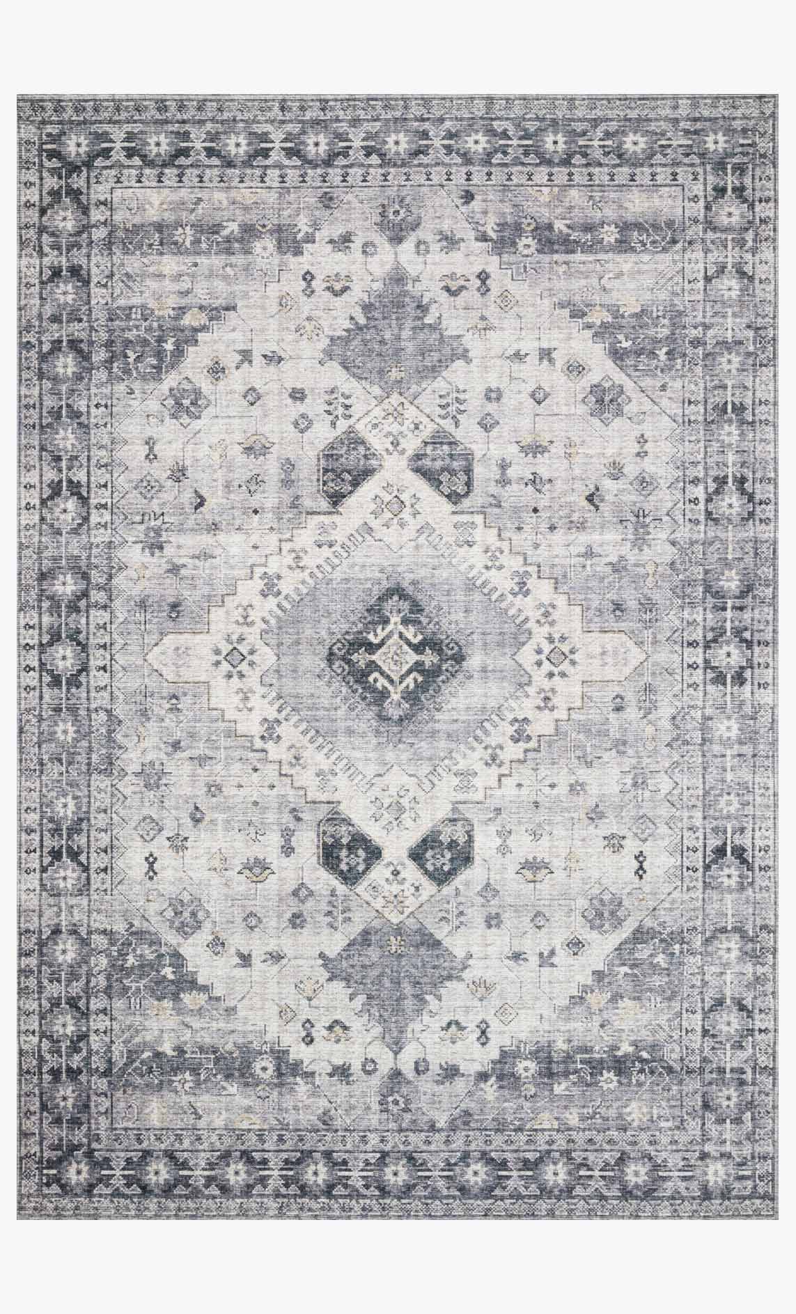 Silver and grey rug with geometric diamond pattern and decorative border.