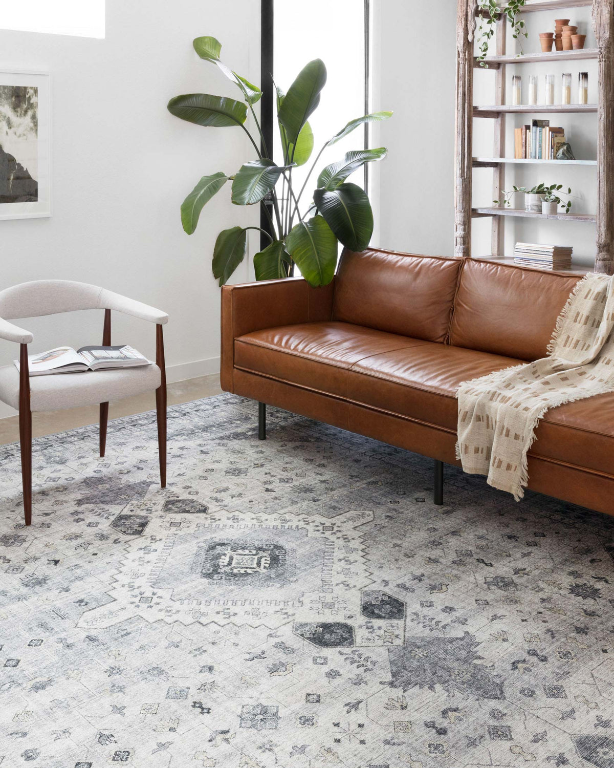 Silver and grey area rug with distressed geometric pattern in an indoor room.