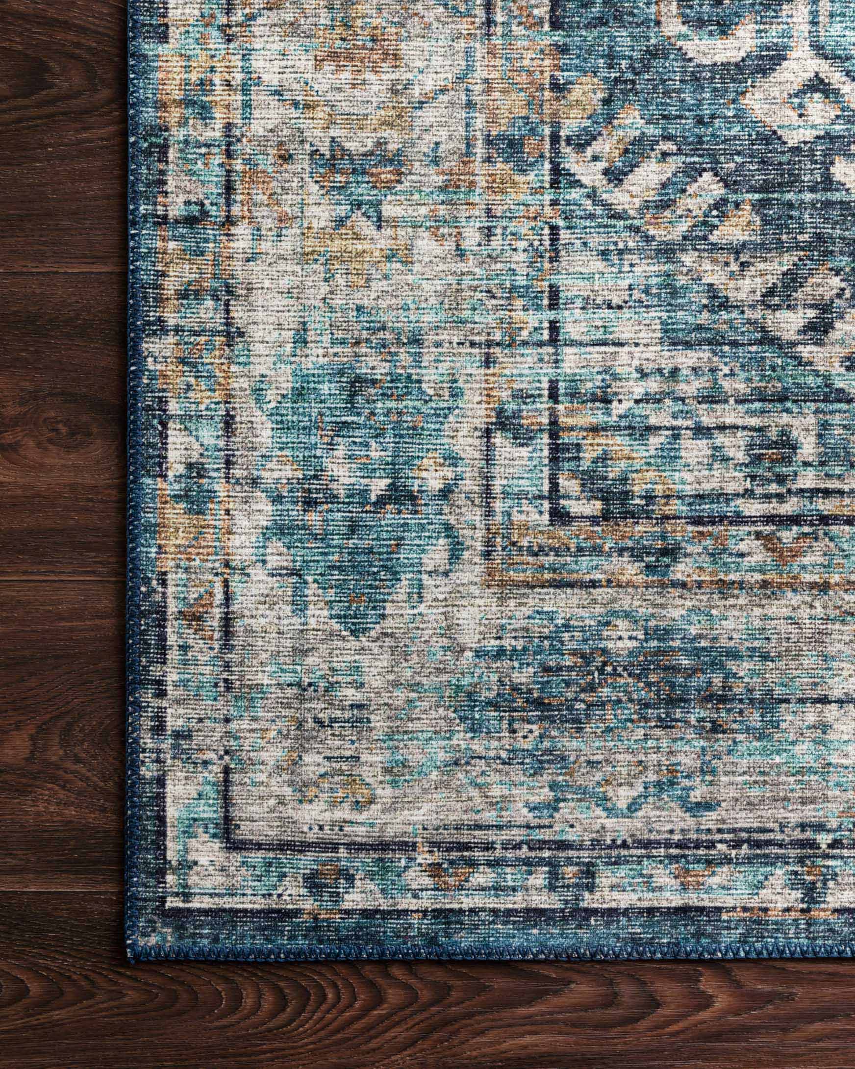 Close-up of denim-blue rug texture with distressed neutral pattern and dark border