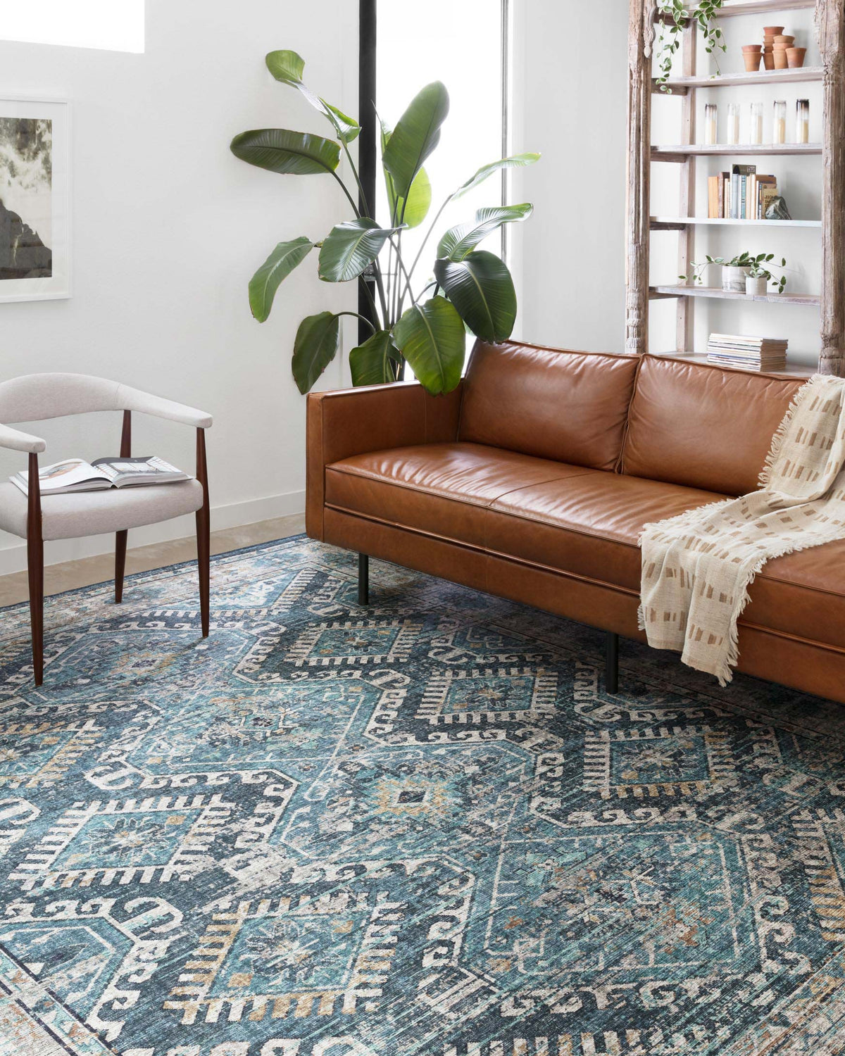 Denim-blue patterned area rug with distressed motifs and ornate border design