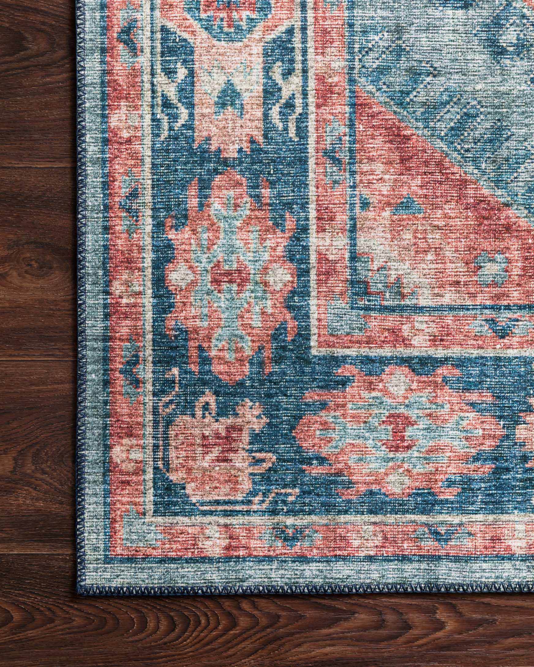 Turquoise and terracotta rug corner detail with distressed motif and woven border