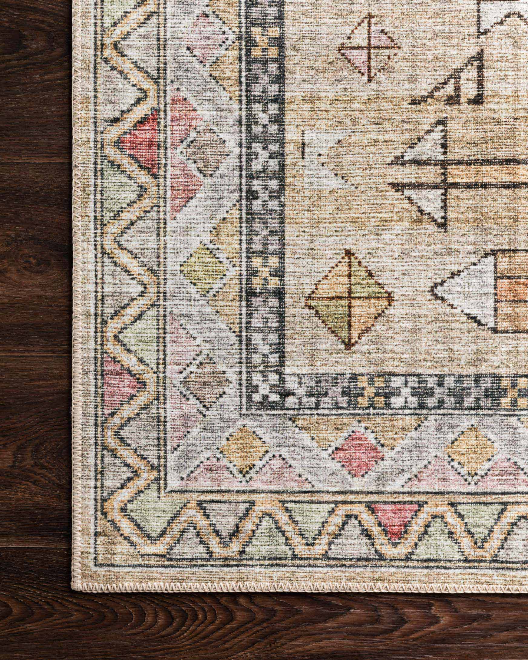 Pattern detail of a traditional rug with zigzag border and arrow motifs in cream and gold