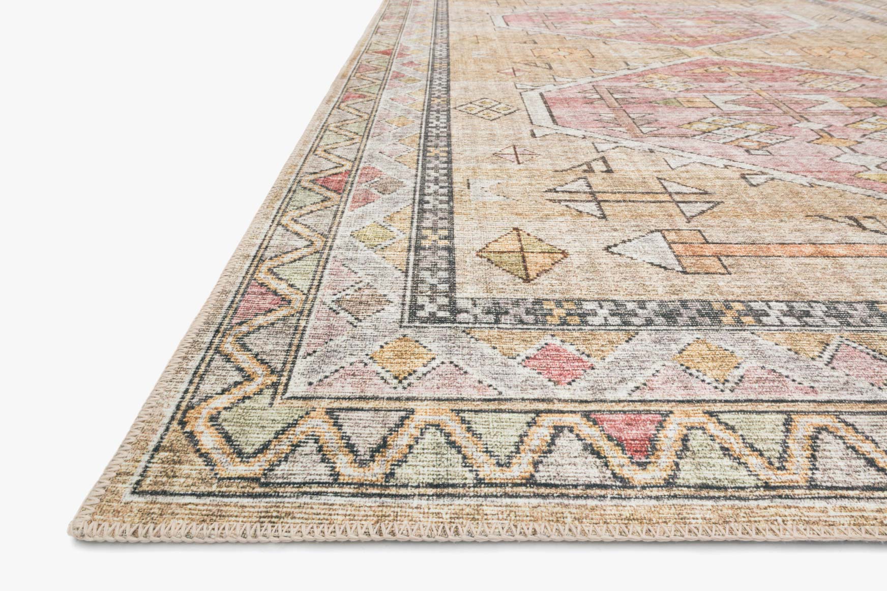 Close-up of traditional rug corner with geometric pattern in cream, gold, and pink