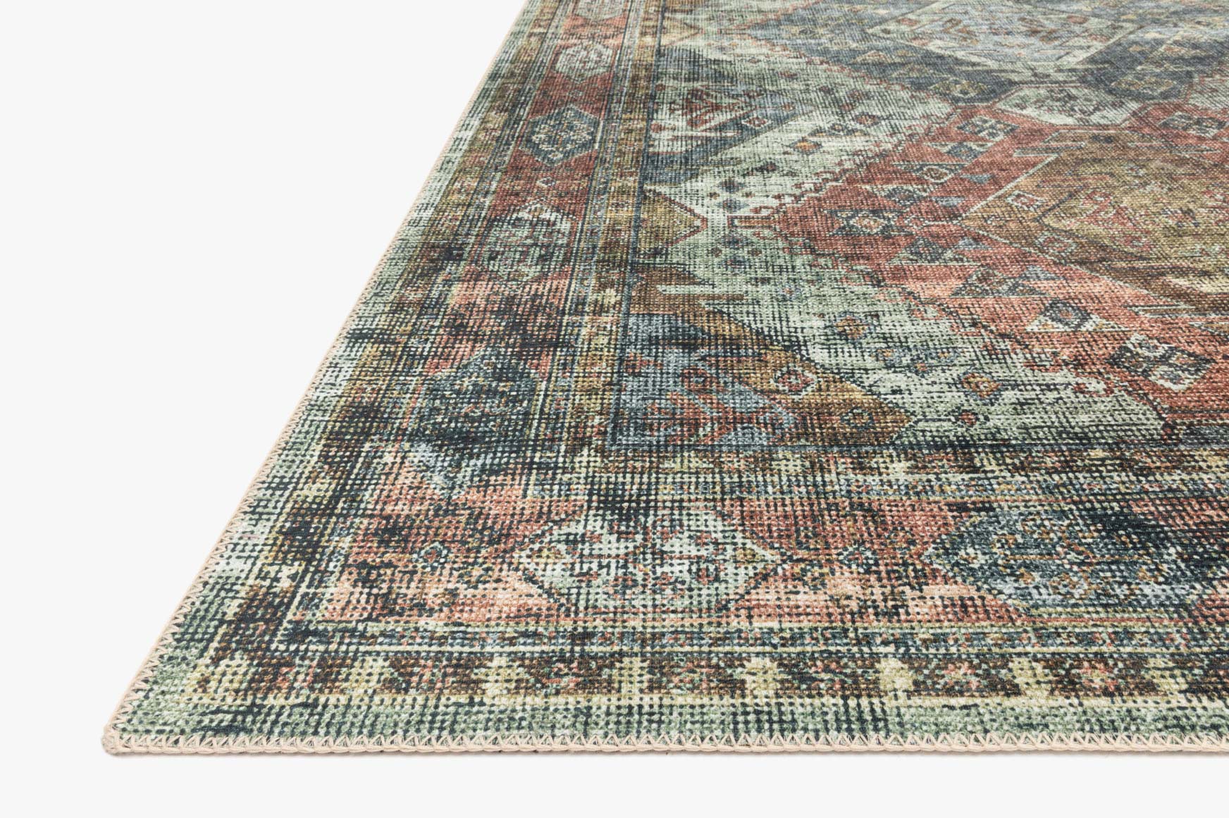 Corner detail of apricot and mist rug showing distressed motifs and textured low pile