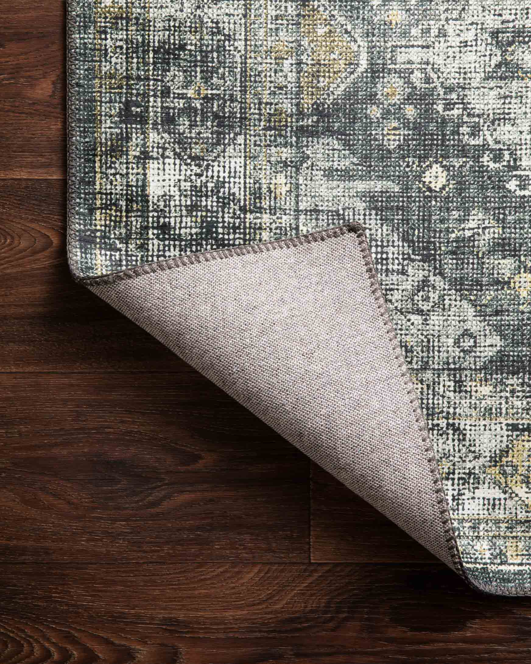 Rug corner detail showing graphite-and-silver geometric weave and beige underside