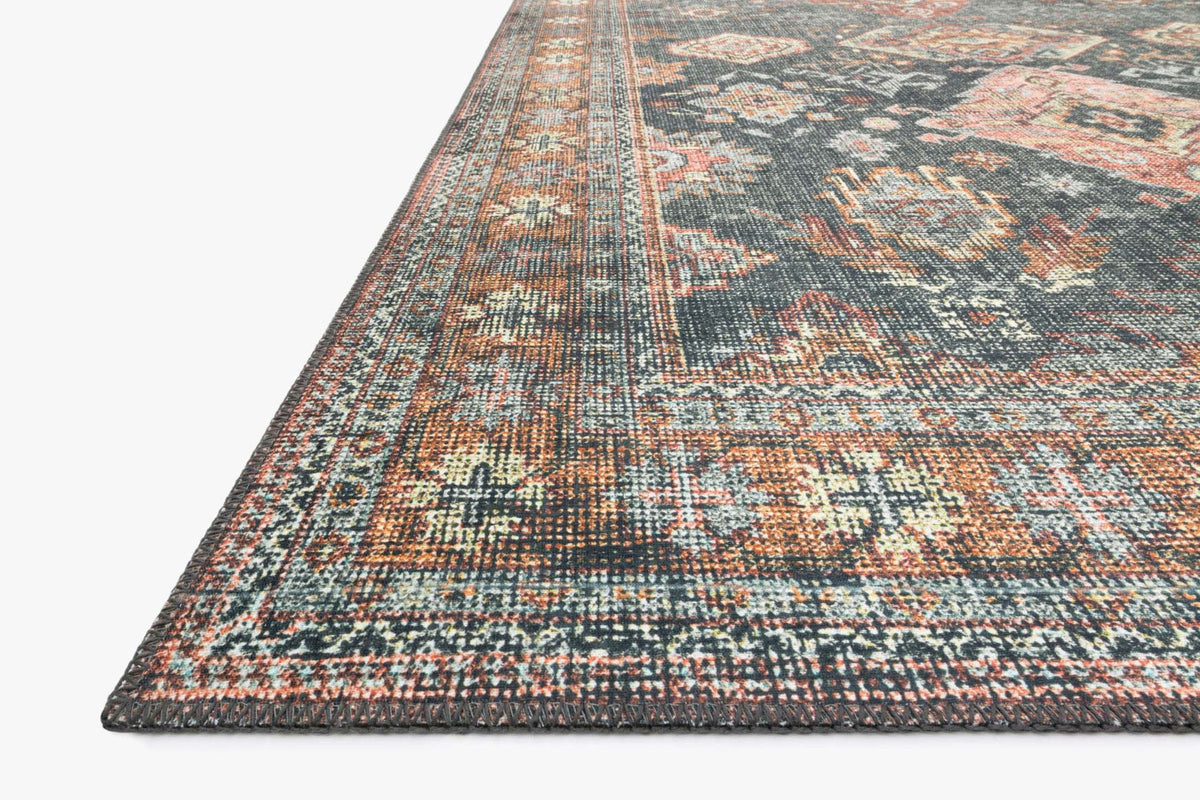 Close-up of traditional rug edge with teal, rust, and beige geometric border