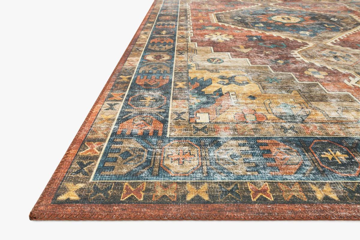 Rust and blue rug corner detail with geometric motifs and border trim