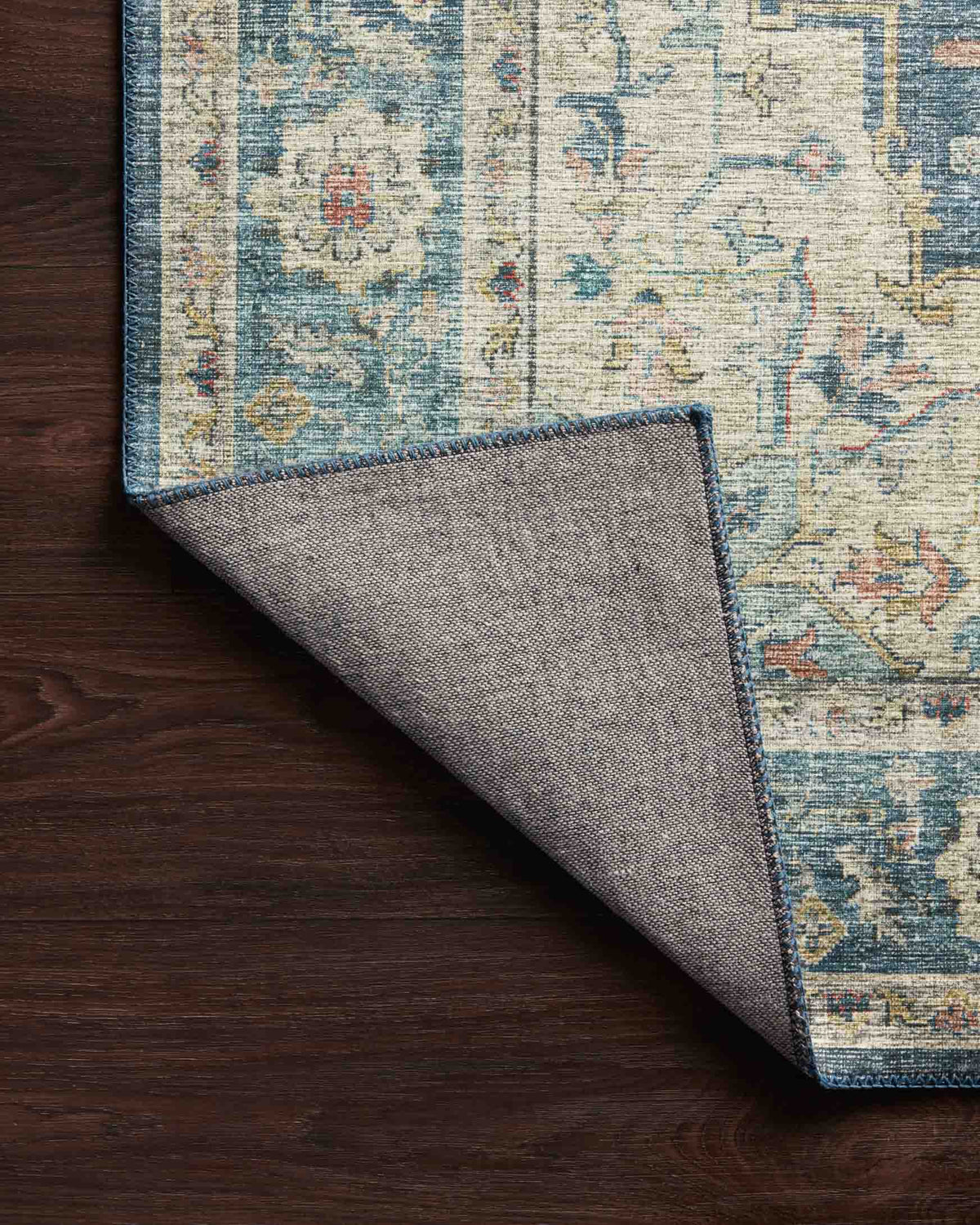 Ocean-blue rug with folded edge showing reverse backing fabric