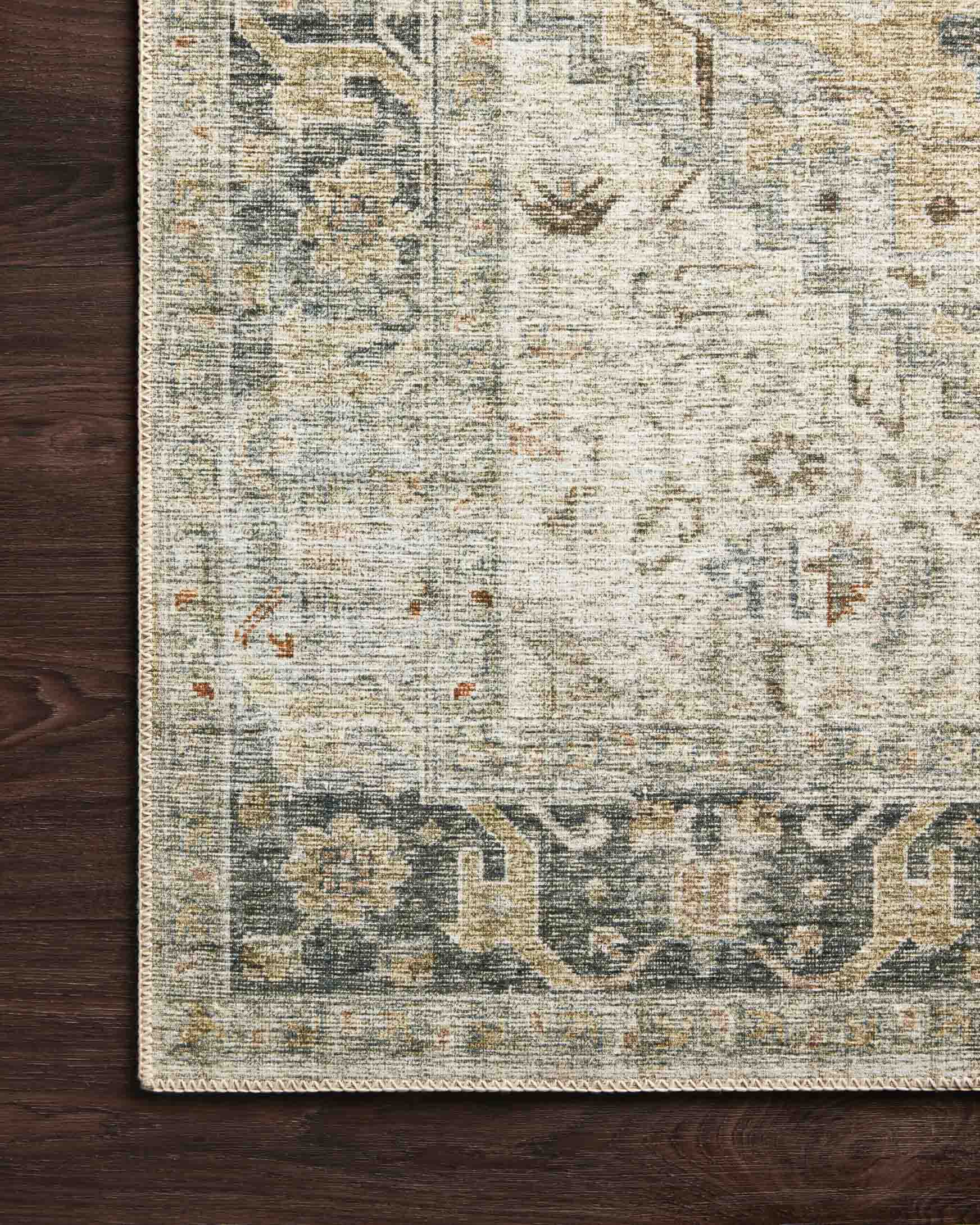 Natural sand rug with faded blue-gray geometric motifs and distressed weave texture