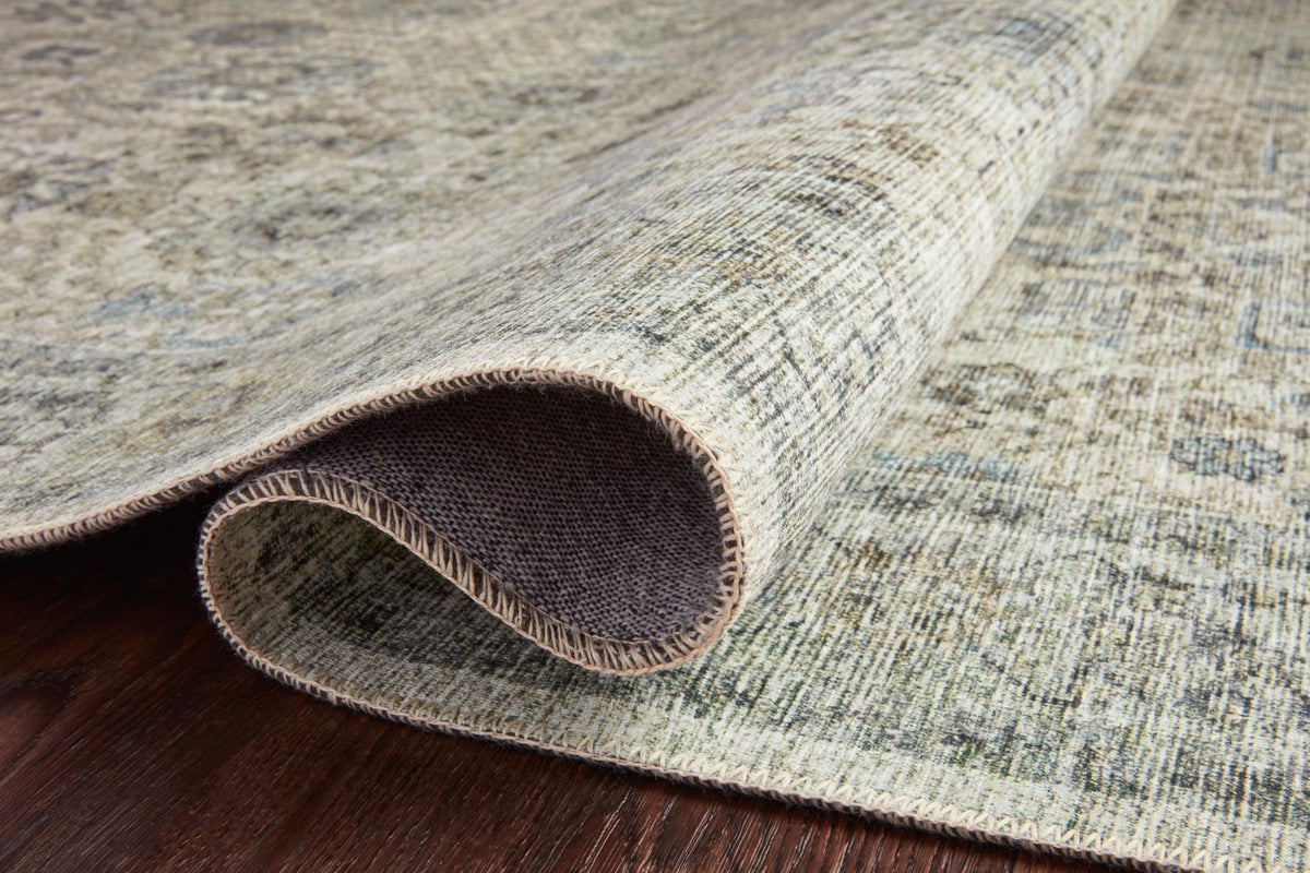 Power-loomed rug edge detail showing dark woven backing in natural and sage