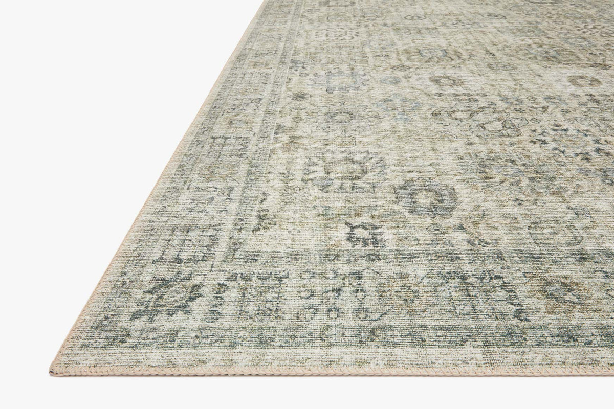 Power-loomed rug corner view in natural and sage distressed geometric pattern