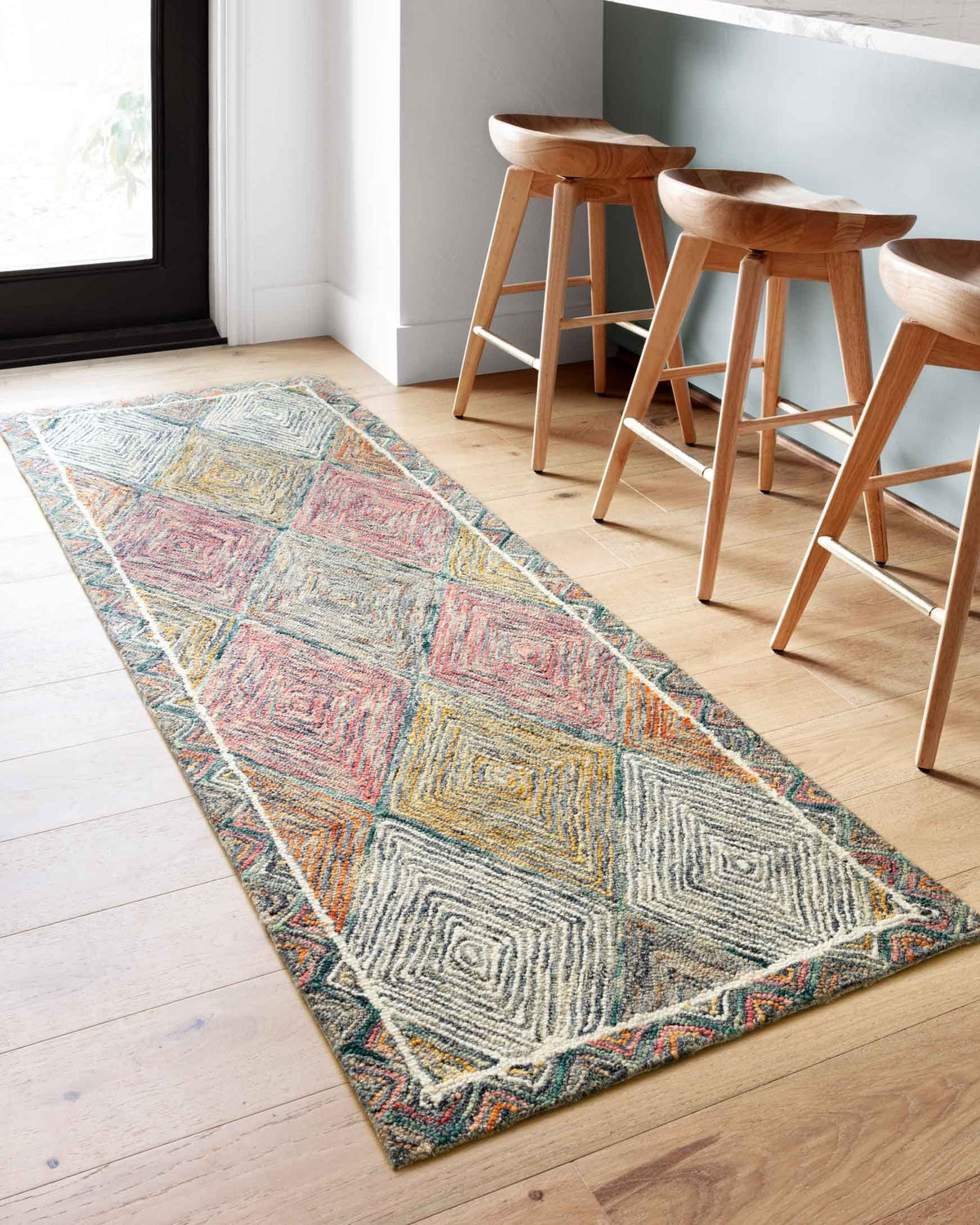 Long hooked area rug with multicolor chevron-and-diamond geometric pattern
