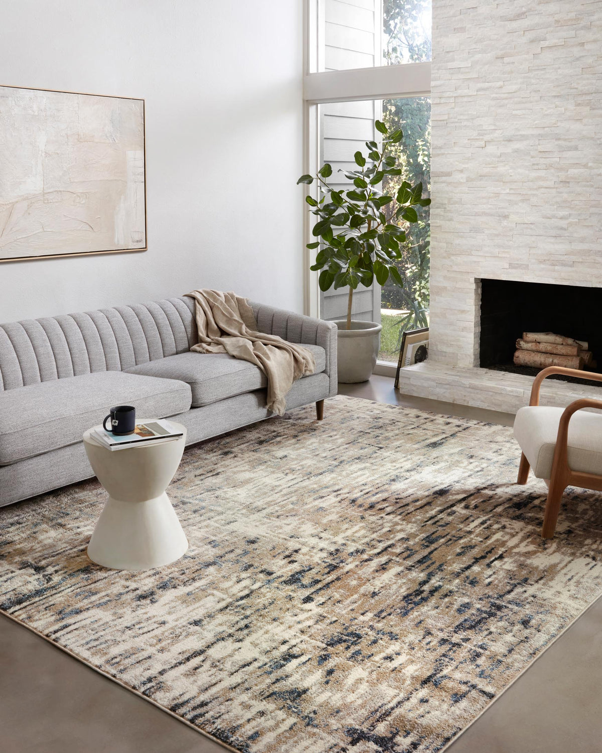 Distressed abstract area rug with beige and blue tones, shown in a living room setting