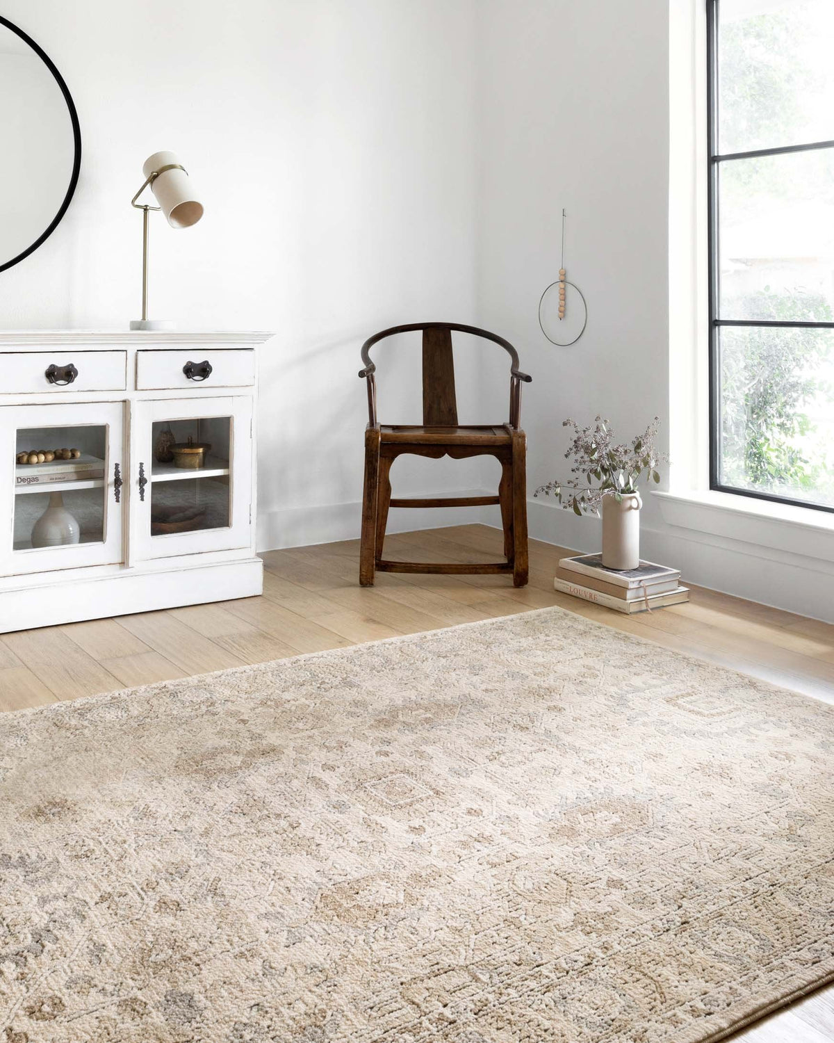 Ivory and sand patterned power-loomed rug laid flat on light wood floor.