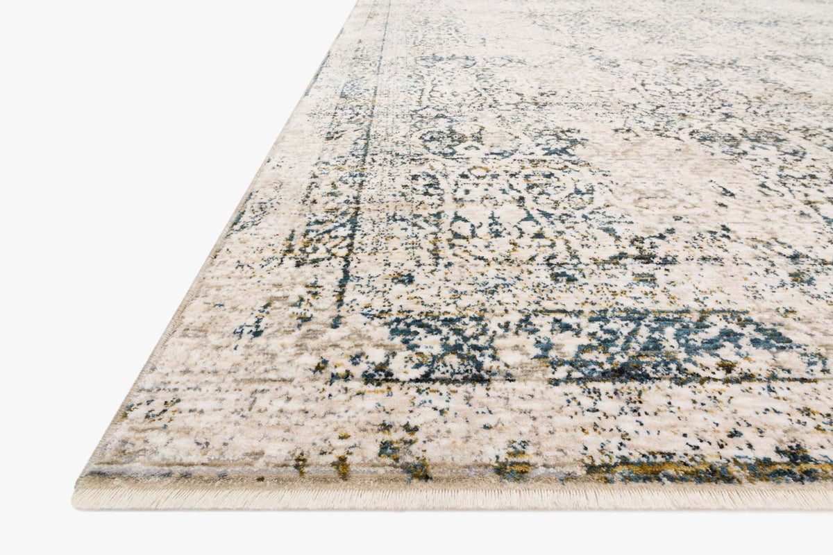 Corner view of traditional power-loomed rug in beige with blue distressed pattern