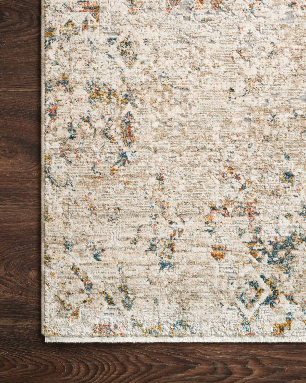 Traditional power-loomed rug edge with multicolor speckled pattern on light ivory ground