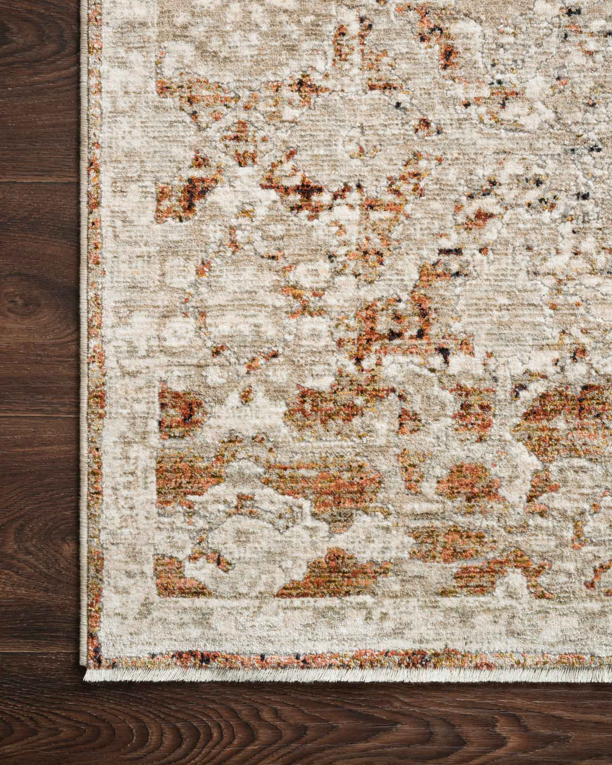 Natural and rust distressed rug close-up with stitched border and textured pile