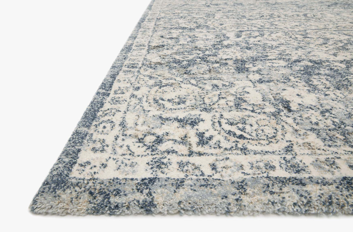 Corner of transitional rug in ivory with blue distressed abstract ornamental motif